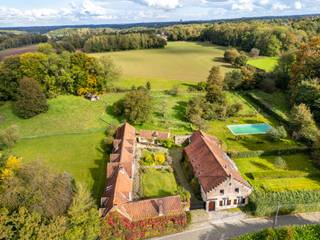 Nestling in one of the most beautiful villages in Walloon Brabant, between meadows and fields, stands the site known as “La Ferme du Champ de France”, dating from the 18th century and listed on the staff plans for the Battle of Waterloo. Set in magnificent grounds of 90 ares, it comprises 2 plots of land with planning permission, each measuring 15 ares, accessed via a little-used road.<br /><br />The ± 500 m² building, partially renovated, comprises 2 main buildings spanning 2 stories with 7 bedrooms, 4 bathrooms, 2 kitchens, 2 study rooms and several living rooms with period vaulted ceilings and open fireplaces. A barn and various units such as a fruit orchard, stables and a workbench open onto a central courtyard that is perfectly orientated, giving it its harmony and unique character. Vegetable garden, orchard, barbecue area, large outdoor swimming pool and lawns make up the setting for this property, which will delight any soul in search of tranquillity.<br /><br />Other features: double garage accessible via the inner courtyard - 3 horse boxes - wine cellars - oil-fired heating - attic - exterior lighting.<br /><br />With its prestigious villas, the village of Ohain in Lasne is renowned for its attractive scenery and its village square, a Belgian Heritage site.<br />
<p>For further information and visits, please contact our office in Walloon Brabant on +32 (2) 898.09.40.</p>