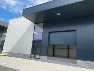Nieuw magazijn van +/- 164 m² met een goede hoogte, grote sectionale deur, laatste isolatienormen (mogelijkheid tot binneninrichting) oppervlakten beschikbaar van 164 m² tot 700 m². Zeer goed gelegen aan de E411, op 3 minuten van de afslag Achêne.