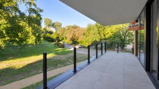 In een nieuwbouwresidentie bevindt zich op de eerste verdieping dit prachtig afgewerkte nieuwbouwappartement. De combinatie van ruimte, veel natuurlijk licht, een hoogwaardige afwerking en een bijzonder groene omgeving maakt dit een zeer aangename plek om thuis te komen.<br /><br />Via de inkomhal bereik je de verschillende ruimtes van het appartement. De ruime en lichtrijke leefruimte geniet dankzij de grote raampartijen van een mooi zicht op het omliggende groen en geeft rechtstreeks toegang tot het ruime terras. Hier geniet je in alle rust van het buitenleven.<br /><br />De open keuken sluit perfect aan bij de leefruimte en is volledig ingericht met kwalitatieve toestellen. Het appartement beschikt over twee volwaardige slaapkamers en twee verzorgde badkamers. Eén badkamer is uitgerust met een ligbad en badkamermeubel, terwijl de tweede badkamer beschikt over een inloopdouche en badkamermeubel. Daarnaast zijn er twee aparte gastentoiletten aanwezig. Een praktische berging met aansluitingen voor wasmachine en droogkast zorgt voor extra comfort en opbergruimte.<br /><br />Ook op vlak van energiezuinigheid scoort dit appartement bijzonder goed. Een warmtepomp en ventilatiesysteem D zorgen voor hedendaags wooncomfort en een laag energieverbruik.<br /><br />Extra troeven zijn de privékelderberging en autostaanplaats. De residentie beschikt over een lift en is modern en verzorgd afgewerkt.<br /><br />Huurprijs: € 1.500/maand<br />Gemeenschappelijke lasten: € 100/maand<br />Onmiddellijk beschikbaar<br /><br />Wie op zoek is naar een ruim, modern en energiezuinig appartement met twee slaapkamers, twee badkamers, een groot terras, veel licht en een groene, rustige ligging, vindt hier een uitzonderlijk complete woonst.<br /><br />Neem contact op met Woonbureau voor meer informatie of een bezoek.