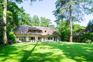 Charmante rietgedekte villa in bosrijke omgeving<br /><br />Deze villa combineert groen, rust en een vlotte bereikbaarheid. Je woont hier midden in de natuur en toch vlak bij de dorpskernen van Schilde en ’s-Gravenwezel, met alle voorzieningen en gezellige horeca binnen handbereik. Ook natuurliefhebbers komen aan hun trekken dankzij de vele wandel- en fietspaden in de buurt.<br /><br />De woning verwelkomt je met een charmante inkomhal en gastentoilet. De ruime leefruimte baadt in licht en biedt een prachtig uitzicht op de tuin. Parketvloeren en een open haard zorgen voor een warme, huiselijke sfeer. Aansluitend vind je de bibliotheek en het kantoor, ideaal om rustig van thuis uit te werken. De keuken is uitgerust met hoogwaardige toestellen en een stijlvol fornuis, terwijl de ontbijthoek uitkijkt op het groen. Extra bergruimte is voorzien in de wasberging en kelder.<br /><br />Boven bevindt zich een royale mastersuite met dressing en badkamer. Daarnaast zijn er drie slaapkamers, waarvan één met ensuite, en een aparte douchekamer. De tuin is onderhoudsvriendelijk aangelegd met volwassen bomen en struiken, waardoor je hier volop geniet van privacy en rust. Het ruime terras sluit mooi aan op de leefruimte en keuken, perfect voor gezellige momenten. Tot slot beschik je over een carport, ruime oprit en tuinberging.<br /><br />Contacteer ons vandaag nog voor een bezoek aan deze unieke woning!
