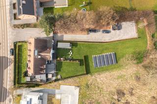 Gelegen op een uitzonderlijk perceel van ca. 3.299 m² met een indrukwekkende straatbreedte van +-41 meter, biedt deze volledig gerenoveerde villa een unieke combinatie van karakter, luxe en hedendaags comfort.<br />De voormalige dokterswoning, vandaag ingericht als stijlvol boutique hotel, onderscheidt zich door haar royale volumes, hoogwaardige afwerking en veelzijdige indelingsmogelijkheden. Dankzij de ruime oppervlakte van 493 m² (bron EPC) leent deze eigendom zich perfect voor wie wonen en werken wenst te combineren, of voor wie op zoek is naar een riante gezinswoning met dat extra beetje ruimte.<br /><br />Indeling gelijkvloers<br />Bij het betreden van de woning word je verwelkomd in een statige inkomhal afgewerkt in marmer.<br />Aan de linkerzijde bevindt zich een eerste ruimte met aparte inkom, ideaal als kantoor, praktijkruimte of vrij beroep, waarbij discretie en toegankelijkheid perfect samengaan.<br />De leefruimte is volledig naar de tuin georiënteerd en geniet van veel natuurlijk licht dankzij de grote raampartijen. De huidige indeling biedt de mogelijkheid om de keuken opnieuw te integreren in de leefruimte, waardoor een royale open woonkeuken kan ontstaan die naadloos aansluit op het terras en de tuin.<br />Verder beschikt het gelijkvloers over een ruime (slaap)kamer met en-suite badkamer, een dubbele garage en een gedeeltelijke kelder (deels volwaardige kelder, deels kruipkelder).<br /><br />Eerste verdieping<br />De bovenverdieping omvat vijf slaapkamers, waarvan vier beschikken over een eigen badkamer. Dit zorgt voor een uitzonderlijk comfortniveau en maakt de woning eveneens geschikt voor gastenverblijf of professionele doeleinden.<br />De luxueuze master bedroom onderscheidt zich door haar royale oppervlakte en beschikt over een mezzanine die perfect kan worden ingericht als dressing, bureau of extra slaapplek.<br /><br />Buitenruimte<br />De uitgestrekte tuin vormt een ware oase van rust en privacy. Dankzij de verschillende terrassen kan op elk moment van de dag genoten worden van zon of schaduw, in alle discretie.<br />De sfeervolle buitenbar maakt het buitenleven compleet en creëert de ideale setting voor ontspanning of stijlvolle ontvangsten. Bovendien zijn alle voorzieningen reeds aanwezig voor de aanleg van een zwembad.<br /><br />Buitengewone kenmerken:<br />- Volledig gerenoveerd<br />- Hoogwaardige en luxueuze afwerking<br />- 5 slaapkamers<br />- 5 badkamers<br />- Airconditioning, alarmsysteem en camerabewaking<br />- Perceel van 3.299 m²<br />- Straatbreedte van ca. 41 m<br />- Zonnepanelen (12.600 Wp)<br />- Grote parking<br />- Ideaal voor vrij beroep of kantoor aan huis<br />- Royale bewoonbare oppervlakte van 493 m² (volgens EPC)<br /><br />Een uitzonderlijke opportuniteit voor wie op zoek is naar ruimte, elegantie en multifunctioneel comfort in een discreet en groen kader.