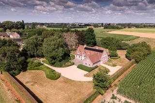 De villa is uiterst rustig gelegen in een rustige straat te Grammene, een deelgemeente van Deinze. Hier woont u omgeven door natuur en rust, terwijl scholen, winkels, openbaar vervoer en verbindingswegen (zoals de N35 en E17) vlot bereikbaar zijn. <br /><br />Bij het betreden van de woning komt u in de ruime inkomhal met een prachtige trap in eik. Via de inkomhal komt u in de ruime en lichtrijke leefruimte met afgewerkt met parket, open haard en grote raampartijen die uitzicht bieden op de tuin en het achterliggende landschap; De keuken met aansluitend de bijkeuken geven toegang tot het zonnige en deels overdekt terras. De leefruimte en keuken bieden de perfecte verbinding met de tuin. Verder bevinden zich op het gelijkvloers een kamer die kan dienst doen als slaapkamer of bureau, een badkamer met lavabomeubel, ligbad en inloopdouche.<br /><br />Op de eerste verdieping bevinden zich nog minimaal 4 slaapkamers waarvan 1 zeer ruime masterbedroom waar aansluitend een dressing kan voorzien worden, een badkamer en een zoldergedeelte die nog verder ingericht kan worden.<br /><br />De ruime garage biedt plaats voor 3 wagens en is verbonden met de woning. <br /><br />In de aangelegde tuin is het zalig vertoeven en heeft u bovendien een weide waar u van het weidse zicht kan genieten of u dieren kunt houden. Door de ligging en omliggende weidse uitzicht geniet u hier van complete privacy.<br /><br />Bovendien heeft u hier meerdere mogelijkheden. Dankzij de slimme indeling en de riante oppervlakte van 320m² leent dit pand zich uitstekend tot het inrichten van een kangoeroewoning.<br /><br />De woning is niet aangesloten op stadswater.<br /><br /><br />Bestuursmaatregelen in het maatregelenregister: nee