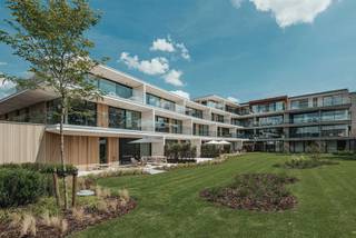 APPARTEMENT 1STE VERDIEPING<br />Het appartement zelf is gezellig ingericht met hoogwaardige materialen. U komt het appartement binnen in de inkomhal met vestiaire en gastentoilet.<br />Via een moderne smeedijzeren deur komt u de grote leefruimte binnen, met open keuken voorzien van alle comfort en aparte berging, eetkamer en woonkamer. In de woonkamer is een vast meubel voorzien welke de mogelijkheid biedt een televisie te plaatsen en aan de achterzijde een apart bureau.<br /><br />Een 2de moderne smeedijzeren deur brengt u in de nachthal met ingemaakte kasten en toegang de wasplaats, masterslaapkamer met inpandige badkamer, 2de slaapkamer en aparte badkamer.<br /><br />Een groot terras van 35m² geeft zicht op de prachtige binnentuin.<br /><br />Staanplaats met berging in de ondergrondse parkeergarage.<br /><br />BIJZONDERHEDEN<br />Het appartement is volledig voorzien van keramische parkettegels met vloerverwarming en passieve koeling.<br />Vaste kosten € 280/maand.<br /><br />POSITIEVE PUNTEN<br />Gelegen in het centrum<br />Energiezuinig<br />Rustig gelegen binnengebied<br />Overdekte terrassen<br />Extra parking voor bezoekers<br />Prachtig aangelegde binnentuin