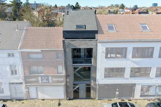 In het hart van Heverlee bevindt zich dit hedendaags opbrengsteigendom (bouwjaar 2010), gekenmerkt door zijn strakke architectuur en multifunctionele invulling. Het gebouw omvat een volledig afgescheiden kantoorruimte en een ruim duplexappartement, wat zorgt voor een interessante combinatie van professioneel en residentieel rendement.<br /><br />De kantoorentiteit strekt zich uit over het gelijkvloers en de eerste verdieping en beschikt over een eigen toegang. Bij het betreden van het pand komt men in een verzorgde onthaalruimte met maatwerk kasten en balie, die naadloos overgaat in een lichtrijke open werkruimte. De grote raampartijen zorgen voor een aangename werkomgeving met veel natuurlijke lichtinval. Verder zijn er een kitchenette en afzonderlijke sanitaire voorzieningen aanwezig. Op de verdieping bevindt zich een afgesloten bureau en een aparte vergaderruimte, wat een duidelijke functionele scheiding mogelijk maakt tussen open werkplekken en discrete overlegmomenten. De kantoorruimte wordt momenteel verhuurd aan € 2.100 per maand en komt vrij op 1 mei.<br /><br />Het duplexappartement, bereikbaar via een aparte inkom, bevindt zich op de tweede en derde verdieping en biedt een comfortabele woonbeleving met mooie volumes. De leefverdieping omvat een inkomhal met gastentoilet, een volledig ingerichte keuken en een aangename, zonnige leefruimte. Op de bovenverdieping bevinden zich twee ruime slaapkamers en een complete badkamer uitgerust met ligbad, douche, wastafel, handdoekradiator en toilet. Daarnaast is er een technische ruimte/wasplaats voorzien. Een ruime zolder biedt bijkomende opslagmogelijkheden. Het appartement is momenteel verhuurd aan € 940 per maand.<br /><br />Beide entiteiten zijn volledig van elkaar gescheiden en beschikken over aparte tellers voor de nutsvoorzieningen, wat het beheer vereenvoudigt en transparant maakt voor huurders. Dankzij de relatief recente bouw, de duurzame materiaalkeuzes en de onderhoudsvriendelijke afwerking kent het gebouw beperkte gemeenschappelijke lasten.<br /><br />De ligging vormt een belangrijke troef: centraal in Heverlee, met vlotte verbindingen naar de E40 en E314 en een goede bereikbaarheid met het openbaar vervoer. Bovendien is er in de nabije omgeving voldoende parkeergelegenheid, wat de commerciële aantrekkelijkheid van het kantoor versterkt.<br /><br />Dit eigendom biedt een stabiele huuropbrengst, flexibiliteit naar de toekomst toe en een aantrekkelijke combinatie van functies op een strategische locatie, een interessante opportuniteit voor investeerders die op zoek zijn naar een solide en veelzijdig rendementspand.