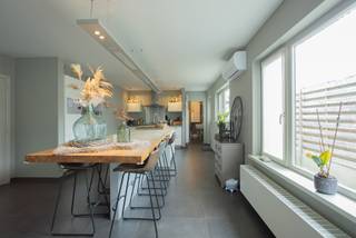 <p><strong>Instapklare laagbouwwoning met zonnige tuin en topligging</strong></p>
<p>Op zoek naar een ruime, lichtrijke woning met een praktische indeling én een uitstekende ligging? Dan is deze charmante laagbouwwoning absoluut een bezoek waard.<br />Deze woning uit 1975 werd grondig gerenoveerd in 2007 en biedt vandaag alle comfort voor wie rustig wil wonen met alle voorzieningen binnen handbereik. Met een bewoonbare oppervlakte van ca. 170 m² geniet u van een aangename leefruimte, veel natuurlijk licht en een doordachte indeling.<br /><br />Indeling:<br />Centrale inkomhal met vestiairekast. Aan de rechterzijde van de woning de ruime living van ca. 55 m², deze vloeit mooi over in de grote open leefkeuken, waardoor een gezellige en open sfeer ontstaat — ideaal voor gezinnen en voor wie graag gasten ontvangt. <br />Verder vanuit de nachthal zijn 3 volwaardige slaapkamers toegankelijk, een inpandige garage, gastentoilet en ruime badkamer, bestaande uit: toilet, dubbele lavabo met meubel, ligbad en inloopdouche.<br /><br />Buiten wacht een volledig omheind perceel van ca. 567 m² met een zonnige zuidwestgerichte tuin. Hier geniet u de hele dag van rust en privacy. Het leuke terras en het tuinhuis achteraan maken het plaatje compleet. Extra praktisch zijn de oprit met poort langs de linkerzijde van de woning en de aparte toegang tot de tuin via een poortje rechts.<br /><br />De ligging is een absolute meerwaarde: rustig gelegen en toch op wandelafstand van het centrum, met winkels, scholen en openbaar vervoer vlakbij. Bovendien bereikt u vlot de belangrijkste invalswegen en de E313.<br /><br />Troeven op een rij:<br />- Laagbouwwoning met praktische indeling<br />- EPC D-label, geen renovatieverplichting<br />- Gerenoveerd in 2007<br />- Zonnepanelen (20m²) en airco's (2023)<br />- Ca. 170 m² bewoonbare oppervlakte<br />- Lichtrijke leefruimte van ca. 55 m² met open keuken<br />- 3 volwaardige slaapkamers<br />- Inpandige garage<br />- Zuidwestgerichte tuin op ca. 567 m²<br />- Volledig omheind perceel<br />- Terras en tuinhuis<br />- Oprit met poort + extra zijtoegang<br />- Centrale en vlotte ligging nabij E313<br />- Elektriciteitskeuring in aanvraag</p>