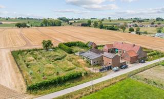 Tussen de velden en in alle rust vindt u deze charmante hoeve met hoofdgebouw, aanpalende schuur en grote open loods met metalen constructie...