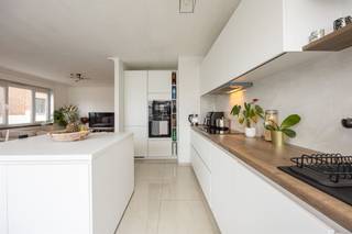 <p><span>Veel licht, een open hedendaagse keuken, drie slaapkamers en een balkon: dit verzorgde appartement aan de Luitenant Lippenslaan combineert een frisse afwerking met een bijzonder praktische indeling. Je woont in Borgerhout extra-muros, met de stad vlot binnen bereik en het groen van ’t Rivierenhof en Te Boelaerpark op wandelafstand.</span></p><p><span>Licht, open en helemaal van nu</span></p><p><span>De inkomhal vormt het centrale hart van het appartement en biedt toegang tot de woon- en slaapvertrekken. Vooraan bevindt zich de royale leefruimte met een gevelbreedte van 6 meter, waar de grote raampartijen en de gunstige hoekligging zorgen voor een overvloed aan natuurlijk licht. Dankzij de extra ramen in de zijgevel geniet je hier van een aangenaam open en luchtig gevoel. Vanuit de leefruimte heb je bovendien rechtstreeks toegang tot het balkon, een fijne plek om even van de buitenlucht te genieten. De lichte laminaatparket loopt naadloos doorheen het volledige appartement en zorgt voor een mooi, harmonieus geheel.</span></p><p><span>De open keuken sluit naadloos aan op de leefruimte en is strak en tijdloos afgewerkt in wit. De vele opbergkasten, het royale werkblad en het centrale eiland maken van deze ruimte een aangename plek waar koken en gezellig samenzijn hand in hand gaan. Ook aan comfort ontbreekt het hier niet: de keuken is volledig uitgerust met een ingebouwde oven en microgolfoven, inductiekookplaat, dampkap, vaatwasser, koelkast en diepvriezer met drie laden.</span></p><p><span> </span></p><p><span>Drie slaapkamers, badkamer én apart toilet</span></p><p><span>In de centrale hal bevinden zich de badkamer en het aparte toilet, dat voorzien is van een handenwasser. Ook de badkamer werd volledig gerenoveerd en kreeg een moderne, tijdloze uitstraling dankzij de stijlvolle betegeling. De ruimte is praktisch ingericht met een comfortabele inloopdouche, een lavabomeubel en een handige aansluiting voor een was- droogcombinatie.</span></p><p><span>Verderop bereik je de drie slaapkamers, die elk genieten van een aangename lichtinval. De kleinste kamer bevindt zich aan de zijkant van het gebouw en leent zich perfect als kinder-, logeer-, dressing-, of bureaukamer. De twee ruimste slaapkamers, waaronder de royale master bedroom, liggen aan de rustige achterzijde van het gebouw met een groen uitzicht en bieden alle ruimte voor een comfortabele inrichting. De verzorgde laminaatparket loopt ook hier naadloos door en zorgt voor een warme, uniforme uitstraling.</span></p><p><span> </span></p><p><span>Borgerhout extra-muros, handig richting stad én Ring</span></p><p><span>Je woont hier op een bijzonder centrale plek, net buiten de stad en vlakbij heel wat groen. Het Te Boelaerpark ligt op wandelafstand, net als het Rivierenhof en Te Boelaerpark. Ook Zurenborg en Berchem Station zijn snel bereikbaar. Met een Mobiscore van 9,5/10 zit je hier uitstekend voor openbaar vervoer, winkels en een vlotte verbinding naar de Ring. Een topligging dus, voor wie rustig wil wonen maar toch met de stad vlakbij</span></p><p><span> </span></p>