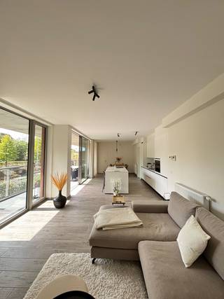 Ruim, lichtrijk en luxueus instapklaar appartement met terras, ondergrondse garage en hoogwaardige technieken op topligging in het hartje van Genk. Door zijn ligging tegen het centrum is dit appartement de perfecte combinatie tussen rust en het stadsleven. Via een privé trap staat u op 2 min. in het centrum. Daarnaast kan u ook gaan wandelen in de groene omgeving van het Molenblook en de Molenvijver.<br /><br />Dit stijlvolle appartement bevindt zich op de eerste verdieping van een modern en kwalitatief gebouw en kan men betreden via een overdekte buitentrap. Bij het binnenkomen in het appartement komt u terecht in een ruime inkomhal die toegang geeft tot een riante en lichtrijke leefruimte met prachtig uitzicht. De living sluit naadloos aan op de open keuken, die volledig afgewerkt is met kwalitatieve toestellen en duurzame materialen.<br />Vanuit de leefruimte heeft u directe toegang tot het overdekt, ruim en zuidelijk georiënteerde terras van 20m2.<br />De badkamer is stijlvol afgewerkt en uitgerust met een moderne inloopdouche. Daarnaast is er een aparte technische ruimte voorzien met aansluitingen voor wasmachine en droogkast.<br />Het appartement beschikt over twee volwaardige slaapkamers die comfortabel en praktisch ingericht zijn. <br />Bij het appartement hoort eveneens een ondergrondse parkeerplaats, 2 standplaatsen voor fietsen en een private berging. Daarnaast is er de optie om in dezelfde kelder nog standplaatsen te huren.<br /><br />Dankzij de combinatie van hoogwaardige afwerking, veel lichtinval en een korte afstand tot het centrum, winkels, scholen en verbindingswegen, vormt dit appartement een aantrekkelijke woonopportuniteit.<br /><br />Troeven:<br />- Geen BTW maar registratierecht<br />- Potentiële huuropbrengst +-1150€/maand<br />- Energiezuinig <br />- Oppervlakte app.: 104,42m2<br />- Hoge plafonds (2,7m)<br />- 2 ruime slaapkamers<br />- Zuidelijk, ruim en overdekt terras: 20,00m2<br />- Private kelderberging<br />- Private parking ondergronds<br />- Afgesloten fietsenstalling<br />- Wandelafstand centrum Genk en toch rustig in het groen