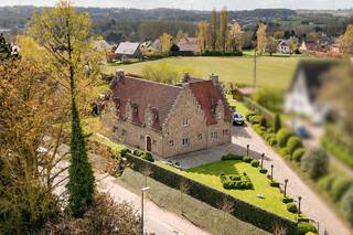 Bent u op zoek naar een instapklare villa op een strategische ligging in Groot-Bijgaarden? Dan stellen wij u graag deze charmante, landelijke woning (bouwjaar 1985) voor, gelegen op een prachtig perceel van 21 are op <strong>Hoogveld 29</strong>.<br />De woning geniet van een uitstekende bereikbaarheid: winkels, scholen, openbaar vervoer en het station van Dilbeek bevinden zich op wandelafstand. Met de wagen bereikt u vlot het centrum van Dilbeek, Ternat en de op- en afritten van de E40.<br /><br />Kortom, de ideale woning voor wie ruimte, rust en een centrale ligging wil combineren.<br /><br /><span>Indeling</span><br /><br />Via de ruime inkomhal met ingemaakte kasten, gastentoilet en een aparte bureauruimte betreden we de woning. Aansluitend bevindt zich de indrukwekkende woon- en eetkamer van maar liefst 62 m², met een plafondhoogte van 6 meter in de leefruimte, wat zorgt voor een bijzonder ruimtelijk gevoel.<br /><br />De ruime leefkeuken is volledig uitgerust en afgewerkt met kwalitatieve materialen. Vanuit de keuken heeft u directe toegang tot de pergola en het zonnige terras van 75 m², dat geniet van optimale privacy en een gunstige zuidoriëntatie.<br /><br />Op het eerste verdiep bevinden zich drie ruime slaapkamers (18 m², 19 m² en 12 m²), een badkamer met ligbad, een aparte douchekamer en een afzonderlijk toilet. De mezzanine vormt hier een absolute meerwaarde en creëert een mooie open verbinding met de woonkamer.<br /><br />De tweede verdieping (zolderverdieping) van maar liefst 58 m² is ingericht als een zeer ruime zolderkamer met sanitaire voorzieningen en bijkomende zolderruimte.<br /><br />Daarnaast beschikt de woning over een ruime kelder en een garage voor twee wagens. Boven de garage bevindt zich nog een polyvalente ruimte met douche, ideaal als hobbyruimte, bureau of extra slaapkamer.<br /><br /><span>Troeven: </span>EPC B – nieuwe ramen – elektriciteit conform – nieuwe verwarmingsketel op aardgas (2025) <br /><br />Is dit de droomwoning voor u en uw gezin? Contacteer ons vandaag nog voor een bezoek ter plaatse!<br /><br /><strong>02 887 80 56 - info@impromove.be</strong>