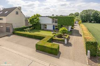 VERRASSEND RUIME, VRIJSTAANDE WONING MET MULTIFUNCTIONELE RUIMTE (TANDARTSPRAKTIJK), DUBBELE GARAGE EN RUIME ZUIDWEST-GEORIENTEERDE TUIN IN VAL-MEER<br /><br />*** Bekijkt u deze woning via een aanverwante website? Surf dan naar https://matisimmo.be/nl/aanbod/4440077/villa-te-koop-in-3770-riemst en klik op volgende link voor het INTERACTIEF GRONDPLAN: https://grondplan.matisimmo.be/grondplan/?map=RiemstVerbindingsweg20 ***<br /><br />Deze opmerkelijk ruime woning met praktijkruimte is gelegen aan de Verbindingsweg 20 te Val-Meer, een deelgemeente van het landelijke Riemst. Dankzij de gunstige ligging zijn alle dagelijkse voorzieningen vlot bereikbaar in de omgeving, evenals de op- en afritten van de E313. Omliggende steden zoals het gezellige Bilzen en Maastricht zijn vlot bereikbaar. Daarbuiten is Riemst gekend om haar vele fiets- en wandelroutes doorheen de groene omgeving en voorbij historische gelegenheden.<br /><br />De woning is verrassend ruim met een woonoppervlakte van maar liefst 231m<sup>2</sup> én beschikt over een multifunctionele ruimte met aparte ingang. Dit vormt een groot pluspunt voor zelfstandigen (in hoofd- of bijberoep).<br />Daarbuiten is de tuin werkelijk een groene oase, piekfijn onderhouden en verschillende gezellige plaatsjes in de tuin om tot rust te komen.<br /><br />We betreden de woning via de inkomhal, die toegang biedt tot de ruime, lichtrijke woonkamer met zit- en eetgedeelte. Aansluitend bevindt zich de volledig ingerichte keuken, die vervolgens toegang geeft tot de praktische wasruimte en de kelder.<br />De woonkamer en keuken geven beide uit op  de achtergelegen veranda. Hier kan men gezellig genieten van de rust en het uitzicht op de mooi aangelegde tuin. De veranda biedt verder rechtstreeks toegang tot het terras.<br /><br />Vervolgens bevinden zich gelijkvloers 2 praktijkruimtes die zowel toegankelijk zijn vanuit de woning (inkomhal en keuken) als via een aparte ingang. Dit geeft tal van mogelijkheden voor een vrij beroep, kantoor of andere professionele activiteit.<br />Het apart toilet is eveneens toegankelijk vanuit de praktijkruimtes alsook vanuit de hal in het privégedeelte.<br /><br />De eerste verdieping is ingericht met een nachthal, een apart toilet en drie ruime slaapkamers. Eén van de slaapkamers beschikt over een aangrenzende ruimte met douchecabine. Daarnaast is er een badkamer aanwezig, uitgerust met een dubbele lavabo, ligbad en douche. Tot slot is er nog een aparte dressingruimte voorzien op deze verdieping.<br /><br />In het woongedeelte sluiten we af met de verschillende kelderruimtes waar de woning nog over beschikt. Deze zijn handig als extra opbergruimte.<br /><br />Tot slot is de woning voorzien van een royaal aangelegde en verzorgde tuin. Vanuit de veranda is het terras toegankelijk en heeft men zicht over de hele tuin. Daarbuiten is de tuin volledig omheind en voorzien van een toegangspoort in het verlengde van de inrit. Verder bevindt zich in de tuin nog een bijgebouw en een tuinhuis.<br />Het bijgebouw is uitgerust met twee garages en beschikt bovendien over een verdieping met drie multifunctionele ruimtes, die ideaal kunnen dienen als hobbyruimte. Met de wagen is de garage toegankelijk via de oprit langs de woning.<br /><br />Nog een extra troef, er werden zonnepanelen voorzien van 4320 Wpiek met groenstroomcertificaten (€450/stuk) tot 2029.<br /><br />Voor meer informatie of een bezoek ter plaatse kan u vrijblijvend contact opnemen met ons kantoor via 089/44.00.00 of info@matisimmo.be.<br /><br />De vermelde woonoppervlakte is steeds de bruikbare vloeroppervlakte overgenomen uit het EPC-verslag.<br /><br /><em>Bestuursmaatregelen in het maatregelenregister: nee</em><br /> 