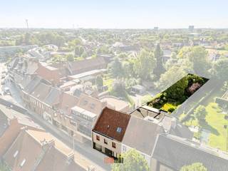 In de Hoogstraat 9 vinden we deze karaktervolle rijwoning waar het grote woonvolume (307m²) je zeker kan verrassen.<br />Een pand met geschiedenis, een kroeg, een kruidenierswinkel en jarenlang een gekende beenhouwerij. De eigendom vraagt een grondige renovatie, maar met wat verbeelding ziet men dat hier een fantastische gezinswoning kan gecreëerd worden. <br /><br />Dankzij de grote bewoonbare oppervlakte, is een uitbreiding hier niet nodig. De bestaande ruimtes kunnen perfect ingericht worden tot de eigen familiale situatie.<br />De voormalige winkel kan eventueel ook verbouwd worden tot garage.<br /><br />Een leuke patio levert veel daglicht aan de aansluitende ruimtes, de XL woonkamer en afzonderlijke keuken kijken op de fantastische tuin (875m²) met veel kleurrijke borders, hoge bomen en een handige tuinberging. Een speelparadijs voor ravotters, een oase van rust voor natuurliefhebbers, dit met zicht op de Kerktoren van de Sint-Petrus en Pauluskerk.<br /><br />De woning biedt ruimte aan een voormalige beenhouwerij (winkel), bureau, inkomhal/fietsenberging, kelder, toilet, woonkamer, keuken, berging, gelijkvloerse badkamer. Op de verdieping bevinden zich 3 volwaardige slaapkamers, de tweede badkamer en een grote zolderruimte (met vaste trap), verder in te rechten als speelzolder, hobbyruimte, extra slaapkamers,...<br />Een woonst met geschiedenis, maar klaar voor een volgend hoofdstuk. <br />Ontdek haar veel troeven en plan vrijblijvend een bezoek in!