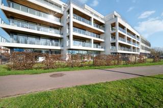 <p>Op de eerste verdieping van een verzorgd en recent gebouw bevindt zich dit aangename appartement met twee slaapkamers en een ruim terras met open zicht op het groen en de waterpartij.</p>
<p>De leefruimte geniet van grote raampartijen over de volledige breedte, waardoor het appartement bijzonder lichtrijk aanvoelt en een sterk gevoel van ruimte creëert. Vanuit de woonkamer heeft u rechtstreeks toegang tot het terras aan de voorzijde, waar u geniet van een open uitzicht over de omgeving en de waterpartij.</p>
<p>De open keuken sluit naadloos aan bij de leefruimte en is modern en functioneel ingericht met diverse ingebouwde toestellen en voldoende werk- en opbergruimte. Aansluitend bevindt zich een praktische berging met aansluiting voor wasmachine en droogkast, evenals de technische installaties.</p>
<p>Via de inkomhal bereikt u het nachtgedeelte met twee volwaardige slaapkamers. De badkamer is verzorgd ingericht en beschikt over een ligbad en een dubbele wastafel. Daarnaast is er een afzonderlijk gastentoilet voorzien.</p>
<p>Het appartement is gelegen vlakbij het gekende Kennedy-rondpunt, een centrale locatie bij het binnenrijden van Oostende met een vlotte verbinding naar het centrum, de kust en de belangrijkste invalswegen.<br /><br /></p>
<p><strong>Troeven van dit appartement</strong></p>
<ul>
<li>Lichtrijke leefruimte met brede raampartijen</li>
<li>Open keuken met moderne afwerking</li>
<li>Ruim terras met open zicht op het groen en de waterpartij</li>
<li>Praktische berging in het appartement</li>
<li>Mogelijkheid tot aankoop van een garage in het gebouw</li>
<li>Centrale ligging vlakbij het Kennedy-rondpunt</li>
</ul>