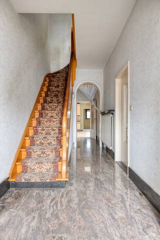 Deze halfopen bebouwing is gelegen vlakbij invalswegen.We betreden de woning via een ruime inkomhal, die toegang biedt tot de living en de open...