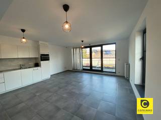 <p><span>Recent, kwaliteitsvol appartement op de eerste verdieping met een mooi aangelegde voortuin, stijlvol afgewerkte inkomhal en trapzaal met lift.</span></p><p><span> </span></p><p><span>We komen binnen in het appartement via een centrale nachthal. De grote woonkamer ligt aan de rustige achterzijde van het gebouw en heeft een open keukenwand met inbouwtoestellen (kookplaat, oven, dampkap, koelkast en vaatwasmachine). Via een groot schuifraam komt men op het terras dat zich uitstrekt over de gehele breedte van de leefruimte en bijna 2 m breed is, voldoende om enkele comfortabele zetels of een kleine eettafel te plaatsen. </span></p><p><span> </span></p><p><span>Beide slaapkamers liggen aan de voorkant en hebben via de kamerhoge ramen toegang tot een klein balkonnetje. Dankzij de super-isolerende ramen komt er geen straatlawaai binnen. Verluchten gebeurt door middel van een mechanisch verluchtingssysteem. De badkamer werd voorzien van een mooie grote inloopdouche en dubbele lavabo.</span></p><p><span> </span></p><p><span>Verder is er een apart toilet met lavabo en een ruime berging met de individuele verwarmingsketel en aansluiting voor een wasmachine.</span></p><p><span> </span></p><p><span>Achteraan het gebouw ligt de overdekte en afgesloten fietsberging en er dient een autostaanplaats gehuurd te worden aan € 55,00. </span></p><p><span> </span></p><p><span>Huurprijs & kosten</span><span><br />Huurprijs: € 950,00 / maand</span></p><p><span>Autostaanplaats: € 55,00 / maand</span></p><p><span>Gemeenschappelijke kosten : € 50,00 / maand (Onderhoud gemeenschappelijke delen)</span></p><p><span> </span></p><p><span>Troeven</span></p><ul><li><span>Modern appartement</span></li><li><span>Aparte meters</span></li><li><span>Uitstekend EPC</span></li><li><span>Lage gemeenschappelijke kost</span></li><li><span>Fietsenberging en autostaanplaats beschikbaar</span></li></ul>