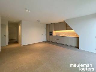 Au cœur de Veldegem, découvrez ce spacieux appartement de trois chambres situé au deuxième étage de la résidence moderne Delphine, construite en 2026. L’alliance d’une architecture contemporaine, de matériaux de haute qualité et de technologies énergétiquement performantes fait de ce logement un lieu agréable à vivre.<br /><br />L’entrée s’ouvre sur un lumineux espace de vie doté de grandes fenêtres, véritable atout pour la luminosité. La cuisine attenante, entièrement équipée avec des appareils haut de gamme SMEG, comprend un lave-vaisselle, une plaque à induction avec hotte intégrée, un combiné réfrigérateur-congélateur et un four à convection. Un espace de rangement pratique avec branchements pour lave-linge et sèche-linge complète cet ensemble.<br /><br />L’appartement dispose de trois grandes chambres doubles, idéales pour une famille, un bureau à domicile ou une salle de loisirs. La salle de bain séparée est finie avec modernité et équipée d’une douche à l’italienne, d’un double lavabo, d’une armoire murale et d’un radiateur porte-serviettes.<br /><br />Un véritable plus est la grande terrasse offrant une vue dégagée remarquable !<br /><br />Côté stationnement et rangement, ce bien offre de nombreux avantages. Un garage privé est inclus dans la location, équipé d’une porte automatique, d’un éclairage et de l’électricité. Une borne de recharge pour véhicules électriques peut également y être installée. Un second garage est disponible en location optionnelle pour 75 € par mois. Les vélos peuvent être rangés en toute sécurité dans le local commun prévu à cet effet.<br /><br />L’appartement est déjà équipé de luminaires et de rails pour rideaux.<br /><br />Grâce à ses caractéristiques à énergie neutre et à ses technologies modernes, vous profitez d’un cadre de vie durable, axé sur le confort et l’efficacité.