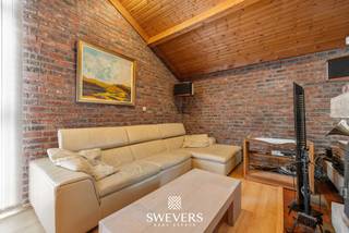 Voor meer info en foto’s, surf naar www.swevers.be – Op een rustige locatie in Koersel wacht deze instapklare open bebouwing op een ruim perceel van 10a 99ca. Met een bewoonbare oppervlakte van 238 m² biedt deze woning alle ruimte voor een comfortabel gezinsleven. De praktische indeling omvat een lichtrijke woonkamer, een tweede zithoek, een functionele keuken en een afzonderlijk bureau, ideaal voor wie thuiswerkt of voor het uitoefenen van een vrij beroep. Op de eerste verdieping bevinden zich vier volwaardige slaapkamers, een badkamer, een apart toilet en een handige zolderberging. Extra bergruimte vindt u in de ruime kelder van bijna 50 m². De inpandige garage en de carport voor twee wagens zorgen voor voldoende parkeergelegenheid. De noordoostelijk georiënteerde tuin biedt tal van mogelijkheden om te ontspannen, spelen of tuinieren, én kijkt uit op agrarisch gebied. Dankzij de luchtverwarming met geïntegreerde verkoeling geniet u het hele jaar door van een aangenaam binnenklimaat. De woning ligt bovendien op korte afstand van scholen, winkels, restaurants, openbaar vervoer en diverse recreatiemogelijkheden, waaronder de B-Mine, Blueberry Fields en het Koersels Kapelleke. Een ideale gezinswoning die ruimte, comfort en een rustige ligging perfect combineert. Voor meer informatie, bel 011 255 155. Bron bewoonbare oppervlakte: EPC – verslag.