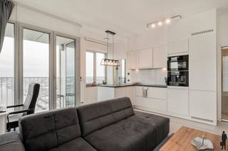 <strong>Wonen boven Antwerpen – Exclusief Panorama op de 19e verdieping</strong><br /><br />Op de 19e verdieping van Residentie Lichttoren bevindt zich dit uitzonderlijk en lichtrijk appartement met een adembenemend panoramisch uitzicht over Antwerpen.<br />De inkomhal geeft toegang tot een stijlvolle open leefruimte waar grote raampartijen het stadszicht centraal stellen. Aansluitend bevindt zich een inpandig terras, ideaal als beschutte buitenruimte in elk seizoen. De moderne open keuken is harmonieus geïntegreerd in het geheel. Het appartement beschikt over een ruime slaapkamer, een volwaardige badkamer en een privatieve berging op niveau -1.<br /><br /><strong>Bijzonderheden:</strong><br />- EPC score B<br />- Privatieve berging (-1)<br />- Autostaanplaats mee aan te kopen voor € 35.000