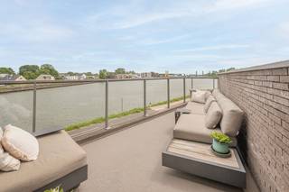 <p>Ontdek deze uitzonderlijk afgewerkte penthouse op een unieke locatie aan het water in Willebroek. Dankzij de grote raampartijen baadt het appartement de hele dag in natuurlijk licht en geniet u van een prachtig ruimtelijk gevoel.</p><p>Via de ruime inkomhal, voorzien van een stijlvolle ingebouwde vestiairekast, betreedt u deze luxueuze woonst. De lichtrijke leefruimte vormt het hart van de penthouse en geeft rechtstreeks uit op het royale, zuidgerichte terras waar u in alle rust kunt genieten van zon en uitzicht op het water. De leefruimte is afgewerkt met hoogwaardige parketvloeren, maatwerk kasten en een elegante ingebouwde gashaard die zorgt voor extra sfeer en comfort.</p><p>Aansluitend bevindt zich de open, volledig geïnstalleerde leefkeuken die naadloos overgaat in de woonruimte. Deze moderne keuken is uitgerust met kwalitatieve toestellen en beschikt bovendien over een geïntegreerde wijnkoeler, ideaal voor liefhebbers van gastronomie en gezelligheid.</p><p>De penthouse biedt twee volwaardige slaapkamers en een aparte walk-in dressing. De klasse volle badkamer is voorzien van een ligbad, ruime inloopdouche en een stijlvolle lavabo met hoogwaardig badkamermeubel.</p><p>Verder beschikt de woning over een praktische berging en een afzonderlijk gastentoilet.</p><p>Deze exclusieve penthouse combineert een toplocatie aan het water met een hoogwaardige afwerking, royale leefruimtes en een overvloed aan natuurlijk licht. Een unieke woonkans voor wie op zoek is naar comfort, luxe en uitstraling op een uitstekende locatie in Willebroek.</p><p></p><p>Het appartement is uiterlijk 1 december 2026 beschikbaar. <br />Stedenbouwkundige inlichtingen aangevraagd. </p><p>Dit pand wordt verkocht onder het stelsel van erfpacht. U koopt het appartement, kelderberging en autostaanplaats zelf, maar huurt de ondergrond. De canon (jaarlijkse vergoeding voor de grond) bedraagt +/- 1200€/jaar. Het erfpachtcontract loop tot en met 17/03/2107.</p>