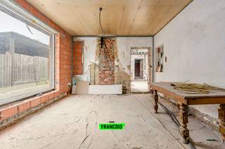 In Lede bevindt zich deze halfopen bebouwing met bijzonder veel potentieel, ideaal voor wie op zoek is naar een renovatieproject waarbij reeds de belangrijkste werken werden uitgevoerd. De woning werd namelijk volledig gestript en de eerste stappen richting een totaalrenovatie zijn reeds gezet. Zo werd de woning volledig asbestveilig gemaakt, voorzien van een nieuw geïsoleerd dak en uitgerust met dubbele beglazing in PVC over de volledige woning. Hierdoor beschikt u reeds over een sterke basis om deze eigendom verder af te werken volledig naar eigen smaak en wensen. De indeling van de woning omvat op het gelijkvloers een inkomhal met toegang tot de woon- en eetkamer. Aansluitend bevindt zich de ruimte die voorzien werd voor de toekomstige keuken, gevolgd door het gastentoilet en de badkamer. Via de traphal bereikt u de eerste verdieping, waar zich momenteel twee verder af te werken slaapkamers en een dressing bevinden. Daarnaast beschikt de woning nog over een zolderverdieping, bereikbaar via een zolderluik. Mits het plaatsen van een vaste trap kan deze ruimte perfect ingericht worden als derde slaapkamer, bureau of hobbyruimte. Een absolute troef van deze eigendom is de zeer ruime garage/atelier van ca. 150 m², bereikbaar via de koer achter de woning. Deze ruimte biedt tal van mogelijkheden voor zelfstandigen, hobbyisten, opslag of het combineren van wonen en werken. Achteraan het atelier bevindt zich bovendien nog een onderhoudsvriendelijk stukje tuin, waar u in alle rust kan genieten van een aangename buitenruimte. Dankzij de reeds uitgevoerde structurele werken, de grote polyvalente ruimte en de bijkomende buitenruimte vormt deze eigendom een uitstekende opportuniteit voor handige renovatoren of mensen die op zoek zijn naar een woning met werkruimte.<br /><br />