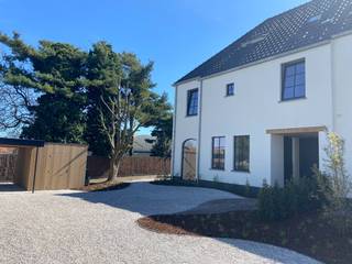 In tweede lijn, omgeven door rust en groen, bevindt zich deze uiterst kwalitatieve nieuwbouwwoning die ruimte, licht en verfijning moeiteloos combineert. De woning ademt een landelijke sereniteit, verfijnd vertaald naar hedendaags wooncomfort met een uitgesproken high-end afwerking. Elk detail werd met zorg gekozen — kosten noch moeite werden gespaard — en enkel duurzame, hoogwaardige materialen vonden hier hun plaats. Een woning die vandaag al klaar is voor morgen.<br /><br />Het betreft de linkse woning bij vooraanzicht (lot 3).<br /><br />De architectuur en indeling zijn doordacht tot in de finesse: royale leefruimtes, een optimale lichtinval dankzij grote glaspartijen en een volledige harmonie tussen binnen en buiten, met zicht en toegang tot de tuin rondom.<br /><br />Ook de buitenaanleg wordt volledig afgewerkt met oog voor esthetiek en functionaliteit. Oprijlaan, voortuin, inkompad, terras en parkeerstroken worden uitgevoerd in waterpasserende kleiklinkers met organische vormen. In de voortuin bevindt zich een carport met extra tuinberging. Zwarte omheining, betonplint en ericamatten zorgen voor maximale privacy, terwijl achteraan een haag van laurierkers een groene, natuurlijke afsluiting vormt.<br /><br />Indeling gelijkvloers:<br /><br />- Royale inkomhal met gastentoilet<br />- Zeer lichtrijke leefruimte met zit- en eethoek<br />- Open, volledig uitgeruste keuken met volkeramisch werkblad met afgeronde hoeken, dubbele spoelbak, inductiekookplaat, telescopische dampkap, koelkast, oven, microgolf en vaatwasmachine<br />- Praktische wasplaats/berging<br />- Afgesloten bureauruimte met stijlvolle stalen deuren<br /><br />Verdieping:<br /><br />- Ruime nachthal<br />- Apart toilet<br />- Drie volwaardige slaapkamers, waaronder een master bedroom met ensuite dressing<br />- Luxe badkamer met ligbad, dubbele lavabo en inloopdouche<br /><br />Via een vaste trap bereikt u de zolderverdieping, waar reeds Velux-ramen voorzien zijn en uitbreidingsmogelijkheden bestaan voor extra kamers.<br /><br />Extra troeven:<br /><br />- Lucht-water warmtepomp met vloerverwarming op gelijkvloers én verdieping<br />- Regenwaterput van 10.000 liter<br />- Zwarte PVC-ramen (RAL 9005) met kleinhouten en dubbele beglazing<br />- Ventilatiesysteem type D<br />- Conforme elektriciteit<br />- Volledige voorbereidingen voor internet, coax, zonneluifel, screens, thuisbatterij en koelcel<br />- Volkeramische vloeren, massief parket in de leefruimte en laminaat op de verdieping<br />- Venstertabletten in arduin<br />- Vaste eiken trappen<br /><br />Kortom: een uitzonderlijk luxueus woonproject dat klasse en tijdloze elegantie uitstraalt, versterkt door de prachtig gekaleide gevels.