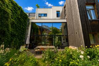 Quares - TREVI Groep presenteert :<br />Deze eigenzinnige woning is ontstaan uit een herenhuis, versmolten met een nieuwbouwwoning. U geniet dus van de prachtige stijl van een herenhuis in het comfort en ruimtelijkheid van een nieuwbouw, met grote glaspartijen, veel lichtinval en een zeer ruime tuin. <br /><br />U komt binnen via de oude woning met prachtige authentieke elementen en geniet onmiddellijk van het comfort van de nieuwbouwwoning met zeer hoge plafonds en een grote raampartij die rechtstreeks uitkomt op de tuin. De breedte van de tuin is 11 meter, ingericht in Piet Oudolfstijl, waardoor je midden in de stad kan genieten van een eigentijdse oase van groen. <br /><br />Omdat de woning meer dan 500m² omvat beschikt u over een grote leefruimte met geïnstalleerde keuken, aangrenzend aan de tuin. Via zwevende betonnen treden komt u in de living. In dit (nieuwbouw) gedeelte van de woning vindt u ook nog drie slaapkamers en een badkamer en dressing. Naast de keuken bevindt zich een grote garage (40m²). Als je in de inkomhal de trap omhoog neemt, komt u in een apart gedeelte van de woning met nog eens vier slaapkamers, twee badkamers, een leefruimte met keuken en een dakterras met prachtig zicht op de stad, dit gedeelte staat volledig los van de andere delen van de woning en wordt momenteel in co-housing gebruikt. De woning is ontworpen door de architecten 'Verdickt & Verdickt '.Ideaal als praktijk of kantoorruimte. <br /><br />De omgeving van de Oude Steenweg bevindt zich in een stukje Antwerpen in volle ontwikkeling, vlakbij de Paardenmarkt via waar je op wandelafstand bent van zowel het toeristische centrum als het bruisende Eilandje. De wijk Dam met park Spoor Noord en de vernieuwde slachthuissite bevindt zich ook op wandelafstand. Aan de woning zelf zijn er volop winkels en openbaar vervoer.