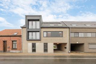 Recent opgeleverde dakappartement met een praktische indeling en een riant terras, waar je in alle rust kan genieten van zon en buitenruimte. Via de inkomhal met gastentoilet kom je terecht in de lichte leefruimte met open keuken. De moderne keuken is afgewerkt met een natuurstenen werkblad en volledig uitgerust met kwalitatieve toestellen, waaronder een inductiekookplaat, dampkap, oven, vaatwasmachine en ingebouwde koelkast. Vanuit de woonkamer heb je directe toegang tot het ruime en zonnige terras, een absolute troef van dit appartement! Het appartement beschikt verder over een ruime slaapkamer en een stijlvolle badkamer met lavabo en inloopdouche. Daarnaast is er een handige berging met aansluiting voor een wasmachine. Het appartement beschikt over een private berging in de kelder, ideaal voor extra stockage. Bovendien voldoet het appartement aan alle hedendaagse energienormen en is het voorzien van vloerverwarming, een warmtepomp, zonnepanelen, ventilatiesysteem C en regenwaterrecuperatie voor de toiletten en mogelijk ook de wasmachine. Zo geniet u van een energiezuinig en comfortabel woonklimaat. Op het gelijkvloers bevindt zich bovendien een praktische gemeenschappelijke berging voor fietsen en vuilnisbakken. Daarnaast is er de mogelijkheid tot het aankopen van een carport voor 20.000 euro (excl. kosten), alle voorzieningen voor een laadpaal zijn reeds voorzien. Extra troef: het verwachte E-peil bedraagt minder dan E20, wat recht geeft op een korting van 50% op de onroerende voorheffing gedurende 5 jaar. AANKOOP AAN 6% BTW MOGELIJK! Contacteer ons voor meer info op 03 568 03 03 of lauren@vastgoed03.be