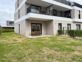 Mooi RECENT lichtrijk appartement bestaande uit een hall, living met open ingerichte keuken, wasberging, 2 slaapkamers, badkamer, apart toilet, terras met tuin vooraan / zijkant / achteraan, carport met berging, private parkeerplaats, 2 fietshaken. Wordt volledig geschilderd verhuurd en voorzien van verlichtingsarmaturen. Hoge plafonds, vloerverwarming en ventilatiesysteem. (60 euro syndiek)