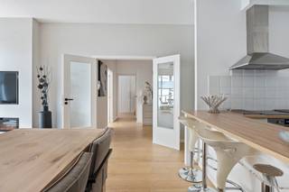 <p><strong>Sfeervol gerenoveerd en gemeubeld appartement in de bruisende wijk ’t Eilandje.</strong></p>
<p>Bent u op zoek naar een modern appartement met een toplocatie? Dit prachtig gerenoveerde appartement in de gewilde wijk ’t Eilandje biedt u de ideale mix van comfort, licht en ruimte. Het bevindt zich op de 3e verdieping van een verzorgd gebouw met lift, direct naast het MAS en op wandelafstand van het stadscentrum, gezellige horeca, culturele hotspots en de Schelde. Ook de haven van Antwerpen ligt vlakbij en een directe tramverbinding zorgt voor snelle toegang tot de binnenstad.</p>
<p><strong>Indeling van het appartement: </strong><span>U wordt verwelkomd in een royale inkomhal met parketvloer, die toegang biedt tot een gastentoilet met wandcloset en een ruime berging/wasruimte. </span><span>De lichte woonkamer is voorzien van grote schuiframen naar het terras voor een overvloed aan natuurlijk licht. Tevens voorzien van een haard-TV meubel met sfeevolle elektrische sierhaard. Verder biedt de</span><span> eigentijdse keuken met eetbarretje, alle hedendaagse apparatuur, waaronder een inductiekookplaat, vaatwasser, combi-oven/microgolf en koel-vriescombinatie. Een elegante bar scheidt de keuken van de woonkamer, wat een gezellige en open sfeer creëert.</span></p>
<p>Verder heeft het appartement twee ruime slaapkamers. De masterslaapkamer heeft een stijlvolle parketvloer en kastruimte. De tweede slaapkamer, direct gelegen naast de living, welke tevens gebruikt kan worden als bureau, heeft een schuifraam naar het terras en biedt prachtige zichtlijnen naar buiten. Een speelse opening tussen de woonkamer en deze kamer zorgt voor extra lichtinval, maar kan eenvoudig worden afgesloten met een harmonica-schuifdeur voor meer privacy. Vervolgens een badkamer met een ligbad/douche-combinatie, voorzien van een douchescherm en dubbele wastafel. </p>
<p><br />Mogelijkheid om ondergronds een autostaanplaats te huren op -2 aan 125 EUR/ maand. <br /><br /></p>
<p><strong>Troeven:<br /></strong><span>- Hoogwaardig en smaakvol gemeubeld appartement<br /></span><span>- Ideale ligging nabij MAS, haven en stad<br /></span><span>- Lift aanwezig<br /></span><span>- Electrische vloerverwarming (gunstig in energieverbruik)</span></p>