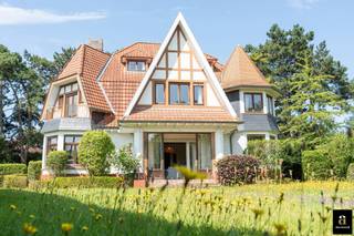 <p>In one of the most beautiful lanes of the Zoute, just steps from the Dominican Church and the prestigious Royal Zoute Tennis Club, lies this charming interwar villa in traditional cottage style. Set on a generous corner plot in the green De Kerckhovelaan, the home is within walking distance of the beach and the Zwin nature reserve.</p>
<p>This distinguished property offers a solid structure with a classic layout: the ground floor includes an entrance hall with staircase, guest toilet, spacious living room, kitchen, garage and boiler room. Upstairs, you will find no fewer than seven bedrooms, two bathrooms and several storage spaces — perfect for a large family or lovers of space and charm.</p>
<p>The authentic façade exudes character and timeless elegance, while the expansive garden ensures privacy and tranquility in an exceptional setting. Thanks to its premium location, this home combines the unique charm of cottage architecture with the sought-after atmosphere of the Zoute.</p>
<p>Additional assets: very large plot, elegant façade, situated in a green and residential area close to the sea, the Zwin and sports clubs. EPC: 625 kWh/m²/year [F label].</p>