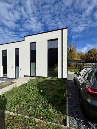 Moderne afgewerkte BEN-woning op een perceel van 4are 49ca in een nieuwe verkaveling.<br />Deze woning is een halfopen bebouwing en is als volgt ingedeeld. Op het gelijkvloers is er een inkomhal met trap naar verdieping, toilet, woonkamer opgedeeld in zithoek en eethoek, open ingerichte keuken, berging. Op de verdieping zijn er 3 slaapkamers waarvan 1 met dressingruimte, badkamer met ligbad, toilet, enkele lavabo en een berging. Naast de woning is er een carport. Terras en tuin zijn toegankelijk via een schuifraam in de woonkamer.<br />Vloer, keuken en badkamer worden door architect en promotor gekozen en geïnstalleerd. U dient enkel nog schilder- en behangwerken te doen en de woning is klaar om bewoond te worden.