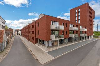 <p>U betreedt het appartement via de inkomhal met vestiaire en gastentoilet. </p><p>De lichtrijke leefruimte met open keuken geeft uit op het terras en de fraai aangelegde binnentuin. </p><p>De moderne keuken is uitgerust met een kookplaat, dampkap, oven en vaatwasmachine. </p><p>Het keukeneiland biedt bovendien extra zitruimte en creëert een gezellige verbinding met de leefruimte.</p><p></p><p>Aansluitend bevindt zich een praktische berging met aansluiting voor wasmachine en droogkast. </p><p>De hedendaagse badkamer beschikt over een inloopdouche en een dubbel lavabomeubel. </p><p>Verder telt het appartement twee volwaardige en lichtrijke slaapkamers.</p><p></p><p>In de ondergrondse garage is een autostaanplaats aanwezig, voorzien van elektriciteit. </p><p>Daarnaast beschikt het gebouw over een gemeenschappelijke afvalruimte en fietsenberging. </p><p>Er bestaat eveneens de mogelijkheid om een ruime garage aan te kopen, ideaal voor het stallen van een voertuig en/of extra opslagruimte.</p><p></p><p>Het appartement geniet van een uitstekende ligging op wandelafstand van het centrum, het station, scholen, winkels en de fietssnelweg F8 tussen Kortrijk en Gent.</p><p></p>