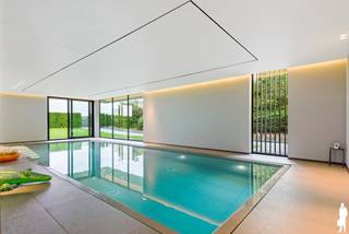 <p><strong>Stijlvol appartement met terras en 2 autostaanplaatsen inbegrepen in de prijs<br /><br /></strong>In de prestigieuze residentie <strong>‘De Kade’</strong>, op een unieke locatie aan de oevers van de Rupel, bevindt zich dit stijlvol en bijzonder verzorgd appartement met een bewoonbare oppervlakte van <strong>109 m²</strong>. De combinatie van tijdloze architectuur, een hoogwaardige afwerking en een uitzonderlijke ligging aan het water maakt dit tot een bijzonder aangename woonplek in Rumst.<br /><br />Bij het betreden van de residentie valt meteen de ruime en lichtrijke inkomhal op. Grote glaspartijen zorgen voor een open karakter en bieden zicht op het gemeenschappelijke wellnessgedeelte met <strong>binnenzwembad en zuidgerichte tuin</strong>. Het volledige domein is bovendien omheind en beveiligd en uitsluitend toegankelijk voor bewoners en hun bezoekers.<br /><br />Ook in het appartement zelf staat licht, ruimte en comfort centraal. De inkomhal beschikt over een praktische ingemaakte vestiairekast en geeft toegang tot de leefruimte. Hier vormen de gezellige zithoek met Faber Bio haard, de eetplaats en de moderne open keuken één mooi geheel. Grote raampartijen zorgen voor veel natuurlijk licht en creëren een directe verbinding met het <strong>ruime, deels overdekte terras van 19 m² met zicht op het water</strong>.<br /><br />De keuken werd stijlvol afgewerkt met een composieten werkblad en spatwand en is uitgerust met kwalitatieve ingebouwde toestellen.<br /><br />Verder beschikt het appartement over <strong>twee volwaardige slaapkamers</strong>, beide voorzien van ingemaakte kasten. De badkamer is ingericht met een ruime inloopdouche en lavabomeubel. Daarnaast is er een afzonderlijk gastentoilet en een praktische berging met aansluitingen voor wasmachine en droogkast en extra opbergruimte.<br /><br />Een absolute troef van residentie De Kade is het <strong>gemeenschappelijke binnenzwembad</strong>, waar bewoners in alle rust kunnen ontspannen met zicht op de fraai aangelegde, zuidgerichte tuin. Daarnaast is er ook een <strong>rechtstreekse toegang naar het jaagpad</strong> voor wandel- of fietstochten.<br /><br />Tot slot beschikt het gebouw over een gemeenschappelijke fietsenberging en bezoekersparking. Bij het appartement horen bovendien <strong>twee privatieve autostaanplaatsen + berging, die reeds inbegrepen zijn in de verkoopprijs</strong>.<br /><br />Een stijlvol en instapklaar appartement met <strong>109 m² woonoppervlakte en 19 m² terras</strong>, voor wie comfortabel wil wonen op een bijzondere locatie aan het water en tegelijk een vlotte verbinding met de E19 en A12 weet te waarderen.<br /><br /><strong>Troeven:<br /></strong>- 109 m² bewoonbare oppervlakte<br />- Terras van 19 m² met waterzicht<br />- Twee privatieve autostaanplaatsen inbegrepen in de prijs<br />- Prestigieuze residentie ‘De Kade’<br />- Unieke ligging aan de Rupel<br />- Lichtrijke leefruimte met Faber Bio haard<br />- Moderne open keuken<br />- Twee slaapkamers met ingemaakte kasten<br />- Gemeenschappelijk binnenzwembad<br />- Zuidgerichte gemeenschappelijke tuin<br />- Lift aanwezig<br />- Gemeenschappelijke fietsenberging<br />- Bezoekersparking<br />- Rechtstreekse toegang naar het jaagpad<br />- EPC-label A</p>