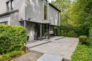<p><span>Ruime op te frissen woning met 4 slaapkamers, wellness, dubbele garage en tal van mogelijkheden!</span></p><p><span> </span></p><p><span>Deze bijzonder ruime woning combineert een royale bewoonbare oppervlakte met tal van mogelijkheden en een uitstekende bereikbaarheid. De woning is momenteel ingericht als</span></p><p><span>kantoorruimte, maar beschikt over een volwaardige residentiële indeling en kan opnieuw worden ingericht tot een comfortabele gezinswoning.</span></p><p><span> </span></p><p><span>Op het gelijkvloers bevindt zich een ruime inkomhal met gastentoilet. Aan de linkerzijde vinden we een afzonderlijke bureauruimte, ideaal als thuiskantoor of praktijkruimte.</span></p><p><span>De royale leefruimte biedt plaats aan zowel een ruime eetplaats als een aparte, gezellige zithoek met gashaard alsook een TV-ruimte.</span></p><p><span>Grote raampartijen zorgen voor veel natuurlijk licht en zijn op het gelijkvloers voorzien van zonneluifels. De woning is hoofdzakelijk afgewerkt met tegelvloeren en beschikt over in de vloer geïntegreerde convectoren.</span></p><p><span>De zeer ruime keuken biedt veel werk- en bergruimte en geeft via de achterdeur rechtstreeks toegang tot het terras en de tuin. Aansluitend bevinden zich nog een praktische berging en bijkeuken.</span></p><p><span>Een absolute troef is de grote polyvalente ruimte, momenteel ingericht met een bar. Onder de huidige vloer bevindt zich het oorspronkelijke binnenzwembad. De vloerconstructie kan opnieuw worden verwijderd, waardoor het zwembad opnieuw in gebruik kan worden genomen en hier een prachtige ontspanningsruimte kan worden gecreëerd. Aansluitend bevindt zich een aparte wellnessruimte met stoomcabine en sanitair.</span></p><p><span> </span></p><p><span>Op de verdieping bevinden zich vier volwaardige slaapkamers. De master bedroom beschikt over ingebouwde kasten. Eén van de slaapkamers heeft een eigen douchekamer. Daarnaast is er een ruime badkamer met ligbad, douche, lavabo en toilet. Ook de verdieping is hoofdzakelijk voorzien van tegelvloeren.</span></p><p><span> </span></p><p><span>Ook aan praktische ruimte is er geen gebrek. De woning beschikt over een zeer ruime, volledig betegelde kelder en een dubbele inpandige garage, rechtstreeks bereikbaar via de oprit.</span></p><p><span> </span></p><p><span>Voor extra comfort is zowel op het gelijkvloers als op de verdieping airconditioning aanwezig. Daarnaast beschikt de woning over een alarmsysteem, een gashaard en werd de verwarmingsinstallatie ongeveer vier jaar geleden vernieuwd.</span></p><p><span>Ook energetisch is er een belangrijke troef: de woning heeft een EPC-score van C, waardoor er geen renovatieverplichting van toepassing is.</span></p><p><span> </span></p><p><span>Buiten valt meteen de uitzonderlijk ruime parking aan de voorzijde op, met plaats voor meerdere wagens. Achteraan geniet u van een mooi terras en een ruime, groene tuin. De achterliggende groene omgeving zorgt bovendien voor een aangenaam en open karakter.</span></p><p><span> </span></p><p><span>De woning kan op bepaalde punten naar eigen smaak worden opgefrist, maar biedt dankzij haar uitzonderlijke ruimtes, vier slaapkamers, binnenzwembad en wellnessmogelijkheden, dubbele garage en ruime buitenomgeving bijzonder veel potentieel. Ook voor wie wonen en werken wil combineren, biedt dit pand interessante mogelijkheden.</span></p><p><span> </span></p><p><span>Troeven:</span></p><p><span> - EPC-score C geen renovatieverplichting</span></p><p><span> - 4 slaapkamers</span></p><p><span> - Zeer ruime leefruimtes</span></p><p><span> - Grote keuken met aansluitende berging en bijkeuken</span></p><p><span> - Binnenzwembad aanwezig onder de huidige vloer</span></p><p><span> - Wellnessruimte met stoomcabine</span></p><p><span> - Airconditioning op gelijkvloers en verdieping</span></p><p><span>- Gashaard</span></p><p><span> - Vloerconvectoren</span></p><p><span>- Verwarmingsinstallatie ca. 4 jaar geleden vernieuwd</span></p><p><span>- Grote, volledig betegelde kelder</span></p><p><span> - Dubbele inpandige garage</span></p><p><span>- Uitzonderlijk ruime parking vooraan</span></p><p><span> - Mooi terras en groene tuin</span></p><p><span>- Achterliggende groene omgeving</span></p><p><span>- Alarmsysteem</span></p><p><span> - Interessant voor combinatie wonen en werken</span></p><p><span> - Goede bereikbaarheid</span></p>