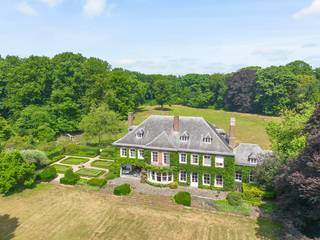 <div>
<div>
<div>
<p>Domein Haezenveld: <br />Te midden van het groen, in een oase van rust en stilte, bevindt zich het prachtige domein Hazenveld. Dit unieke eigendom, gebouwd in 1938 door de grootvader van de huidige eigenaars, met een prestigieuze villa als stralend middelpunt, combineert grandeur met functionaliteit en biedt een droomplek voor wie zoekt naar luxe, ruimte en privacy in het noorden van Antwerpen.<br />Villa Hazenveld: Tijdloze elegantie<br />Bij aankomst worden bezoekers verwelkomd in de ruime inkomhal, waar de gezellige sfeer direct voelbaar is. Hoogwaardige materialen, zoals authentiek parket en vast tapijt, brengen warmte en klasse in elke ruimte. De ruime ontvangstruimtes bieden een gezellige setting voor tal van mooie momenten. Van de eetkamer met hoge plafonds en brede deuren tot de sfeervolle bibliotheek met open haard en ingemaakte kasten: dit is wonen op topniveau.<br />Het grote salon, voorzien van verschillende zithoeken en eveneens een open haard, nodigt uit tot gezellig samenzijn. Voor wie van buitenleven houdt, is er het overdekte terras met uitzicht op de prachtige parktuin.<br />De villa is bovendien volledig uitgerust met praktische ruimtes zoals een ruime keuken, met aparte eethoek, een ruime wasplaats en toegang tot de kelder met wijn- en voorraadkelders.<br />De imposante trap leidt naar de eerste verdieping, waar maar liefst vier luxe slaapkamers zich bevinden, waarvan 1 met open haard en balkon. Elke kamer heeft zijn eigen karakter en is afgewerkt met verfijnde details. En-suite badkamers bieden het ultieme comfort. Voor extra flexibiliteit zijn er drie bijkomende kinderkamers en een salon of hobbyruimte, met eigen toegang via aparte trap.<br />Op de zolderverdieping wordt de veelzijdigheid van deze woning nogmaals benadrukt. Hier vindt u verschillende kamers die perfect dienst kunnen doen als aparte personeelsvertrekken met badkamer of berging.<br /><br />Bovendien staat er nog een conciërgewoning met aansluitend 3 garages. (gedeeltelijk verhuurd).<br /><br />Mogelijkheid tot het bijkopen van een landelijk woonhuis met tuin (ca. 5.000 m², blauwe zone op de luchtfoto) (Veldhuis) met gezellige benedenverdieping en 3 slaapkamers. (momenteel verhuurd) en extra bos en weide van ca. 42.000m².<br /><br />Een domein met uitstraling<br />De parktuin rondom de villa is adembenemend. Met een vijver, Franse tuin, unieke eeuwenoude bomen en weilanden voor paarden, biedt het domein een harmonie tussen natuur en luxe. Een te renoveren zwembad en tennisveld wachten op een nieuwe eigenaar om deze parels weer tot leven te brengen.<br />Daarnaast beschikt het domein over een moestuin met bijhorende tuinkasten, ideaal voor wie houdt van culinaire creaties met eigen geteelde groenten.<br /><br />Domein Hazenveld is een zeldzame vondst. Het combineert authentieke elegantie met hedendaags comfort en biedt een uitzonderlijk niveau van privacy. Dit is een plek waar u volledig tot rust komt en tegelijkertijd een statement maakt.<br />Bent u klaar om de magie van Hazenveld zelf te ervaren? Aarzel niet om contact op te nemen. Wij begeleiden u graag op een exclusieve rondleiding door dit unieke domein.</p>
</div>
</div>
</div>
<div>
<div></div>
</div>