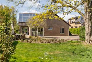 Voor meer info en foto’s, surf naar www.swevers.be – In de rustige en groene omgeving van Dool (Helchteren) ligt deze ruime, instapklare open bebouwing op een perceel van 1.074 m². De woning, gebouwd in 1980 en grondig gerenoveerd in 2020, biedt een bewoonbare oppervlakte van maar liefst 279 m² en combineert comfort met functionaliteit. U betreedt de woning via een inkomhal met gastentoilet. De lichtrijke leefruimte van ca. 40 m² sluit aan op een moderne, volledig uitgeruste open keuken van ca. 20 m² met zicht op de tuin. Op het gelijkvloers bevinden zich drie slaapkamers (18 m², 15 m² en 12 m²) en een badkamer met bad en douche. Verder is er een praktische berging/wasplaats en een ruime kelder.<br />Op de verdieping vindt u een vierde slaapkamer (18 m²) en twee ruime zolders (samen ca. 46 m²) met potentieel voor extra kamers, bureau of hobbyruimte. De woning beschikt verder over een kelder van 40 m² en een vrijstaande dubbele garage van 35 m². De zuidoost gerichte tuin biedt veel privacy en een open zicht op groen en agrarisch gebied. Extra troeven zijn zonnepanelen, nieuwe ramen, een condensatieketel, airco en conforme elektriciteit. Rustig gelegen, met scholen, winkels en openbaar vervoer in de buurt en een vlotte verbinding naar de snelweg. Voor meer informatie, bel 011 255 155. Bron bewoonbare oppervlakte: EPC – verslag.