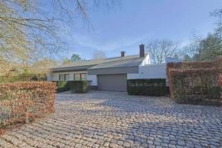 <p><span>Op een uitstekende locatie vlakbij het prachtige domein van Bokrijk en centraal tussen Genk en Hasselt, vinden we deze ruime en karaktervolle villa. De woning combineert rust, privacy en een groene omgeving met een vlotte bereikbaarheid. Deze gezinswoning, uit 1975, is zeer goed onderhouden en onderging in 1995 een renovatie. </span></p><p><span>Bij het betreden van de woning komt u in een ruime inkomhal met vestiaire en gastentoilet. Het gelijkvloers biedt een aangename leefruimte met zithoek, ruime eetplaats en keuken, aangevuld met een wintertuin die een directe verbinding vormt met het terras en de tuin. </span></p><p><span>Grote raampartijen zorgen doorheen de woning voor veel natuurlijke lichtinval en bieden vanuit verschillende ruimtes een mooi zicht op de volgroeide tuin. </span></p><p><span>Verder bevindt zich op het gelijkvloers een bureauruimte, een master bedroom met aansluitende badkamer en dressing, een extra kamer die kan dienen als slaapkamer of hobbyruimte en praktische ruimtes zoals een was- en strijkruimte.</span></p><p><span>Op de eerste verdieping bevinden zich nog een polyvalente ruimte, drie slaapkamers, een douchekamer en meerdere zolder- en bergruimtes die extra mogelijkheden bieden. Daarnaast beschikt de woning over een kelder en een inpandige garage voor twee wagens met een aparte (technische) berging en een afvalberging. </span></p><p><span>De villa is gelegen op een ruim perceel met een prachtig aangelegde tuin en een zuidelijk georiënteerd terras waar u in alle rust en privacy van het groen kan genieten. De tuin vormt een echte troef van deze eigendom, met verschillende groene zones, overdekte terrassen, sierfontein en een charmant tuinhuis achteraan het perceel. Dankzij de ruime oprit en bijkomende parkeermogelijkheden is er bovendien voldoende plaats voor bezoekers. </span></p><p><span>Als extra is er een (verkeersvrije) buurtweg die toegang biedt tot de achterliggende wijk. </span></p><p><span>Kortom, deze villa biedt een unieke combinatie van ruimte, privacy en ligging, ideaal voor wie comfortabel wil wonen in een groene omgeving met alle voorzieningen in de nabijheid. </span></p><p><span> </span></p><p><span>Extra's: afzelia houten ramen, houthaard, parketvloer, airco, natuursteen, tuinberegening, Miele-keukentoestellen, kruipkelder, ...</span></p><p><span> </span></p><p><span>De naastgelegen, zuidgeoriënteerde bouwgrond van 17are32 is optioneel aan te kopen aan 249 000,- EUR. Dit maakt momenteel deel uit van de tuin, ideaal als investering! </span></p><p><span> </span></p><p><span> </span></p>