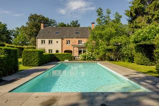 Bijzondere ruime villa (bew. opp. 487m² + poolhouse) met 5 tot 7 slaapkamers, 3 badkamers, dubbele inpandige garage, zwembad, poolhouse enz. Deze villa is gelegen is gunstig gelegen op een mooi aangelegd perceel van 2665m² in een groene omgeving op de grens met Halle en Schilde en in directe nabijheid van in-en uitvalswegen, winkels, scholen enz.<br /><br />INDELING: Via automatische toegangspoort betreden we het perceel met voldoende parkeergelegenheid, dubbele carport enz. - Royale inkomhal met gastentoilet - Zeer ruime leefruimte met mooie lichtinval d.m.v. het vele raamwerk - Vervolgens grote keuken met aanpalend aangebouwde veranda (2013) - Verder is er een aparte eetkamer/polyvalente ruimte en een dubbele garage alsook wasplaats - V1: Grote nachthal met toegang tot 5 slaapkamers en 3 badkamers waarvan 1 masterbedroom met aanpalend dressing en badkamer. V2 omvat een grote zolderruimte en ruimte voor technieken (mogelijk 2 slpk's extra). Tuin: Geheel aangelegd en mooie vormgeving d.m.v. de perceelsbreedte van ca. 30m en voorzien van zowel zwembad als poolhouse (2005). Verder is er nog een grote dubbele carport vooraan de woning voorzien en is er een grote kelder.<br /><br />BIJZONDERHEDEN: Zeer ruime en tijdloze woonst - Ideaal voor grote gezinnen, wonen/werken enz. - Cv gas vloerverwarming + radiatoren - EPC: 204 UC: 3893860 - Destijds kwalitatieve materiaalkeuze doch opfrissing nodig - Pscore: B: Gscore: A - Stedenbouwkundige informatie in aanvraag.