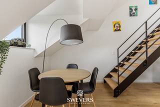 Voor meer info en foto’s, surf naar www.swevers.be – Op de derde verdieping van een verzorgd gebouw aan de Erasme Ruelensvest in Leuven bevindt zich dit instapklare appartement van 58 m². Dankzij de ligging vlak naast de ring en op korte afstand van het stadscentrum geniet je hier van een uitstekende bereikbaarheid, zowel richting Leuven als naar de belangrijkste invalswegen. De praktische indeling zorgt voor een aangenaam wooncomfort. Via de centrale inkomhal bereik je alle ruimtes. De leefruimte van 33,20 m² vormt het hart van het appartement en biedt voldoende plaats voor een gezellige zithoek en eethoek. Ingebouwde kasten zorgen hier voor extra opbergruimte. Aansluitend bevindt zich de functionele keuken van 8,46 m², ingericht langs twee zijden met voldoende werk- en kastruimte. Verder beschikt het appartement over een ruime slaapkamer van 16,32 m² en een tweede kamer van 8,25 m² die perfect dienst kan doen als bureau, logeerkamer of extra slaapkamer. De badkamer en het toilet zijn afzonderlijk ingericht, wat het dagelijkse comfort verhoogt. Daarnaast is er een praktische berging aanwezig. Extra troeven zijn de energiezuinige afwerking, de ingebouwde kasten, de airconditioning en de parlofoon. Het appartement is volledig instapklaar en biedt een aangename woonomgeving met alle voorzieningen binnen handbereik. Scholen, winkels, openbaar vervoer, restaurants en ontspanningsmogelijkheden bevinden zich op wandel- of fietsafstand, terwijl de snelweg vlot bereikbaar is. Een ideale opportuniteit voor alleenstaanden, koppels of investeerders die op zoek zijn naar een verzorgd appartement op een strategische locatie in Leuven. Voor meer informatie, bel 011 255 155. Bron bewoonbare oppervlakte: EPC – verslag.