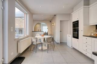 Dit mooie huis nabij het centrum is instapklaar ... <br /><br />Achter de mooie gevel schuilt dit gezellig eigendom. We komen binnen langs de hal met vestiaire. De living is ruim en gezellig ingericht mede dankzij de gashaard en boog tussen voor- en middenplek. De woonkamer gaat naadloos over in de open keuken met ontbijthoek. Achter deze keuken bevindt zich een apart toilet en badkamer met dubbele lavabo en grote instapdouche. <br />Achter de woning, en via de garage bereikbaar, bevindt zich een werkplaats van 40 m2 die dienst kan doen als atelier, hobbyruimte, .... Deze werkplaats beschikt over 2 ingangen en geeft uit op de diepe tuin. In deze diepe zuidwest-gerichte tuin met terras is het heerlijk genieten in alle rust. Op het einde van de tuin bevindt zich nog een tuinhuis met overkapping.<br />De 1e verdieping beschikt over 3 grote slaapkamers en een toilet. Er is eveneens een vaste trap naar de zolder. De geïsoleerde zolder is ontzettend groot. Er zitten 2 grote velux-ramen. Hier kan men met gemak nog een aantal kamers onderbrengen. <br />Vanop het terras heeft men ook toegang tot de grote garage met elektrische poort. <br />Er is tevens een handige kelder en op het dak liggen 10 zonnepanelen. <br /><br />Centrale verwarming op gas. <br />Blanco gekeurd elektriciteitskeuringsverslag en geen renovatieplicht!<br />Achteraan is er de mogelijkheid om een extra atelier bij aan te kopen, palend aan het eigendom. Meer info via ons kantoor.<br /><br />Een instapklare woning, gelegen nabij het centrum, vlakbij winkels, openbaar vervoer, ….