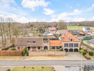 <span>CONTACT </span><br /><span>Jeroen Vandormael: jeroen@vastgoedvalkenborgh.be | 0498/05.76.72 </span><br /><br />Achter hoge, verzorgde scheidingsmuren in de Gildestraat 1 en 3 te Koersel (Beringen) gaat een eigendom schuil die zich niet meteen prijsgeeft, maar des te meer verrast eens men haar betreedt. Deze unieke eigendom bestaat uit twee volwaardige woonentiteiten, die uitsluitend in hun geheel worden verkocht en samen een uitzonderlijke totale bewoonbare oppervlakte van circa 904 m² vertegenwoordigen. <br /><br />De architectuur en opstelling van het geheel werden duidelijk doordacht met oog voor discretie, ruimte en multifunctionaliteit. Hoewel de woning aan de straatzijde bewust gesloten is opgevat, geniet het volledige complex binnenin van een aangename lichtinval en een open, luchtige beleving. Privacy en rust gaan hier hand in hand met ruimte en potentieel. <br /><br />Het hoofdgebouw vormt het hart van de eigendom en valt op door zijn royale volumes en grote leefruimtes. De leefvertrekken zijn ruim opgevat en bieden tal van mogelijkheden voor een hedendaagse herinrichting, zonder hun statige karakter te verliezen. Daarnaast beschikt dit gebouw over twee afzonderlijke burelen, wat het bijzonder geschikt maakt voor thuiswerk of een vrij beroep in eigen woning. <br /><br />Een absolute troef is de prachtige tuinkamer, uitgevoerd in eiken materialen, die het hoofdgebouw verbindt met de rechterwoonst. Deze ruimte vormt een natuurlijke overgang tussen binnen en buiten en is bij uitstek de plek waar het in de zomer heerlijk vertoeven is — of dat nu tijdens een barbecue, een tuinfeest of een rustig familiemoment is. <br /><br />Op de eerste verdieping bevinden zich vijf volwaardige slaapkamers, allen voorzien van ingebouwde kasten. De zeer ruime nachthal, eveneens uitgerust met maatwerkkasten, versterkt het gevoel van comfort en ruimte. Verder zijn er drie badkamers, waarvan één privatief aansluit op de master bedroom. <br /><br />De rechterwoonst biedt een totaal andere, maar minstens even interessante invulling en maakt deze eigendom werkelijk uniek. In het souterrain werd een uitgebreid garagecomplex voorzien voor drie wagens, met automatische poorten en comfortabele toegang. Daarboven bevinden zich op de eerste en tweede verdieping zeer ruime polyvalente ruimtes, die zich uitstekend lenen voor een herbestemming tot volwaardige woonfunctie, praktijkruimte, atelier of kangoeroewoning. Een keuken en een toilet zijn hier reeds aanwezig, wat de flexibiliteit van deze entiteit verder onderstreept. <br /><br />Een bijzonder element van deze rechterwoning is het wellnessgedeelte, uitgerust met een verwarmd binnenzwembad, sauna, turks stoombad, meerdere douches, een aparte toiletruimte en een kleedkamer. Deze zone biedt een uitzonderlijke basis voor wie wellness aan huis wenst te integreren, zij het dat hier ruimte is voor een hedendaagse opfrissing naar eigen smaak en comfort. <br /><br />Daarnaast beschikt deze woonentiteit ook over een indrukwekkende kelderverdieping, ingericht als feestzaal met aansluitende bar — een ideale setting voor private evenementen, ontspanning of hobbydoeleinden. <br /><br />Deze eigendom onderscheidt zich door haar schaal, indeling en veelzijdigheid, en is bovendien gelegen op een volledig omheind perceel dat privacy en rust garandeert. Ze leent zich perfect voor wie wonen wil combineren met werken, voor grote of samengestelde gezinnen, voor een kangoeroewoning of voor wie nood heeft aan ruimte voor een vrij beroep, atelier of praktijk.<br /><br />Het geheel vraagt opfrissings- en modernisatiewerken, wat toekomstige eigenaars de kans biedt om deze uitzonderlijke volumes volledig naar eigen inzicht en hedendaagse normen in te vullen. De solide basis, het karakter en de beschikbare oppervlakte maken dit echter tot een uitzonderlijk dankbaar renovatieproject met een zeldzaam eindresultaat. <br /><br />Een eigendom als deze komt zelden op de markt: discreet gelegen, uitzonderlijk ruim, multifunctioneel en boordevol potentieel — klaar om door de juiste visie opnieuw tot volle glorie te worden gebracht. <br /><br />INDELING <br />Linkerwoning: <br />Gelijkvloers: <br />Inkomhal met vestiaire, afzonderlijk toilet en bureel, bijzonder ruime woonkamer met eet- en zithoek, bijkomend apart bureel, keuken met rechtstreekse toegang tot de wasplaats/berging, aparte ontbijthoek met toegangsluik en trap naar de kelder, waar zich een uitzonderlijk sfeervol ingerichte ruimte bevindt, en rechtstreekse toegang tot een prachtig uitgewerkte tuinkamer in eikenhout. <br />Eerste verdieping: <br />Ruime nachthal met ingebouwde kasten, vijf slaapkamers waarvan één master bedroom met privatieve badkamer (ligbad, douche en dubbele lavabo), alle slaapkamers voorzien van maatwerk kasten, twee bijkomende badkamers, afzonderlijk toilet. <br />Zolderverdieping: <br />Zolderverdieping: praktische ruimte, geschikt voor opslag. <br /><br />Rechterwoning: <br />Inkomhal met afzonderlijke inkomdeur, garagecomplex met plaats voor drie wagens, toegang tot het zwembad- en wellnessgedeelte met douches, kleedruimtes en afzonderlijk toilet, op de eerste en tweede verdieping bijzonder ruime polyvalente ruimtes, bijkomend afzonderlijk toilet en keuken, via een brede trap toegang tot de kelderverdieping waar zich een sfeervolle feestzaal met bar bevindt, evenals een aparte ondergrondse ruimte bestemd voor de cv-installatie en zwembadtechnieken. <br /><br />TROEVEN <br />- twee volwaardige woonentiteiten, uitsluitend in geheel te koop <br />- uitzonderlijke totale bewoonbare oppervlakte van ca. 904 m² <br />- discrete en residentiële ligging achter hoge scheidingsmuren <br />- zeer ruime en lichtrijke leefvolumes met sterke indeling <br />- hoofdgebouw met vijf slaapkamers, drie badkamers en meerdere burelen <br />- prachtige eiken tuinkamer als verbindend element tussen beide entiteiten <br />- rechterwoning met polyvalente ruimtes, garagecomplex en wellnessgedeelte <br />- binnenzwembad, sauna, turks stoombad en doucheruimtes <br />- kelderverdieping ingericht als feestzaal met bar <br />- geschikt voor combinatie wonen/werken, vrij beroep of kangoeroewonen <br />- groot renovatiepotentieel met solide basis en uitzonderlijke schaal <br />- volledig omheinde tuin <br /><br />BEKNOPT <br />Bewoonbare opp: 904m² <br />Oppervlakte perceel: 17are 70ca <br />EPC: 393 kWh/m²/jaar (linkerwoning) en 331 kWh/m²/jaar (rechterwoning)- energielabel D <br />CV: stookolie <br />Jaar einde opbouw: 1976 (linkerwoning) en 1997 (rechterwoning) <br />Vraagprijs: 849.000 euro excl. registratierechten <br /><br />Meer info: <span>www.vastgoedvalkenborgh.be</span> <span>of via 0498/05.76.72 </span>