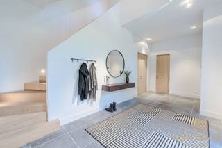 <p>In de gegeerde Bloemenwijk te Retie bevindt zich deze royale villa op een perceel van 2.415 m², waar tijdloze elegantie en hedendaagse luxe elkaar ontmoeten. De woning straalt karakter en klasse uit, met hoge plafonds, een doordachte indeling en een hoogwaardige afwerking die nog deels naar eigen smaak kan worden voltooid. Bovendien geniet u van een uitstekende bereikbaarheid, op slechts 25 minuten van zowel Eindhoven (NL) als Antwerpen (BE).<br /><br />Gelijkvloers<br />De majestueuze inkomhal met stijlvolle trappartij vormt het hart van de woning en zet meteen de toon voor het verfijnde interieur. Aan de rechterzijde ligt een ruim bureel met ingemaakte maatkasten, perfect voor wie van thuis werkt. Via dubbele deuren betreedt u het gezellige salon met gashaard, aansluitend een aparte TV-hoek en een doorgang via een elegante passerelle naar de riante family-kitchen. Deze leefkeuken biedt ruimte voor een grote eettafel, een open haard en is nog deels af te werken naar eigen voorkeur. De aansluitende bijkeuken, afgewerkt in dezelfde verfijnde stijl, biedt extra bergruimte en toegang tot de dubbele garage.<br /><br />Eerste verdieping<br />Op de bovenverdieping bevindt zich de ruime mastersuite met dressing en badkamer (nog gedeeltelijk af te werken). Daarnaast zijn er drie bijkomende slaapkamers, elk met veel lichtinval, en een praktische wasplaats.<br /><br />Tweede verdieping<br />De trap leidt verder naar de tweede verdieping, waar extra kamers zijn voorzien — ideaal als hobbyruimte, speelkamer of logeerkamer.<br /><br />Een exclusieve villa die rust, ruimte, klasse en centrale ligging perfect combineert.</p>