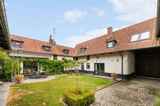 Set on a magnificent, fully fenced landscaped lot of over 5,600 m², this charming property offers approximately 600 m² of living space and features remarkably spacious rooms in a privileged setting.The ground floor opens onto a spacious, double-depth entry hall leading to a 75 m² reception room with a fireplace, which opens widely onto the inner courtyard and garden. The fully equipped kitchen features a utility room and a pantry.An elegant 65 m² master suite completes this level, featuring a bedroom, walk-in closet, and private bathroom.Upstairs, the hallway leads to four beautiful bedrooms, two fully equipped bathrooms, and a study.A converted barn houses a relaxation area with a jacuzzi, pool table, changing room, and shower.Outside, the tree-lined garden, the intimate inner courtyard, the pond, and the heated pool create a rare living environment, sheltered from prying eyes.The property also features two garages with motorized doors, cellars, an attic, and a climate-controlled wine cellar.Features: gas central heating, wood-burning fireplace, double-glazed windows, solar panels, heat pump-heated pool, alarm system, security cameras, video intercom, solid hardwood floors, water cistern, and two garden cottages. Energy Performance Rating: CA unique property combining elegance, comfort, and serenity, in the heart of Néchin.