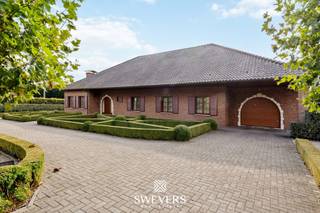 Voor meer info en foto’s, surf naar www.swevers.be - Deze instapklare villa in Halen biedt met haar 395 m² bewoonbare oppervlakte, 318 m² kelder en 340 m² zolder een zee aan ruimte én mogelijkheden. Gelegen op een perceel van bijna 50 are, geniet je hier van een zuidelijke oriëntatie en volledige privacy in een smaakvol aangelegde tuin. Alle leefruimtes bevinden zich op het gelijkvloers: een lichtrijke woonkamer van 44 m², volledig uitgeruste leefkeuken met toegang tot de veranda, drie ruime slaapkamers, een badkamer met bad én douche, aparte wasruimte en gastentoiletten. De enorme kelder is ideaal voor opslag, hobby of werkruimte, terwijl de zolder dankzij de vaste trap en dakramen perfect in te richten is. De inpandige garage biedt plaats voor twee wagens. Extra troeven: vloerverwarming, elektrische rolluiken, alarmsysteem en uitstekende isolatie.<br />Gelegen op minder dan 1 km van winkels, scholen en de E314. Openbaar vervoer op slechts 125 meter. Voor meer informatie, bel 012 699 900. Bron bewoonbare oppervlakte: EPC – verslag.
