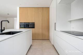<strong>E-peil 4 (!!) – EPC slechts 6 kWh/m²</strong><br /><br /><strong>Laat je verrassen door deze recente en tot in de puntjes afgewerkte nieuwbouwwoning<u> met reeds aangelegde tuin</u> met een bewoonbare oppervlakte van 175 m², gelegen in het hart van Ruien. Op wandelafstand van winkels, scholen en het prachtige Kluisbos geniet je hier van een ideale combinatie van comfort, natuur en bereikbaarheid.</strong><br /><br /><u><strong>Indeling</strong></u><br />Via de ruime inkomhal met gastentoilet kom je binnen in een lichtrijke leefruimte met open keuken en zicht op de volledig aangelegde tuin met zonneterras – de perfecte plek om te ontspannen of gasten te ontvangen. De aangelegde oprit biedt plaats voor meerdere wagens. De praktische berging naast de keuken en de aparte bureauruimte op het gelijkvloers zorgen voor extra comfort en flexibiliteit.<br />Op de eerste verdieping vind je 3 ruime slaapkamers, een volledig uitgeruste badkamer én een afzonderlijk toilet.<br />Topscore op energie en afwerking:<br /><strong>Dankzij doordachte keuzes in materialen en technieken geniet je van maximaal comfort met een minimaal energieverbruik. Met een uitzonderlijk EPC van slechts 6 kWh/m² hoef je je geen zorgen te maken over energiekosten.</strong><br /><br /><u><strong>5 keer WAUW:</strong></u>
<ul>
	<li>Super energiezuinig: 6 kWh/m²</li>
	<li>Volledig aangelegde tuin, terras én oprit</li>
	<li>Kwalitatieve en smaakvolle afwerking</li>
	<li>Aparte bureauruimte voor thuiswerk of hobby</li>
	<li>Centrale ligging op wandelafstand van het Kluisbos</li>
</ul>
<u><strong>Deze woning is écht instapklaar, buiten én binnen.</strong></u><br /><br />Zin om deze parel zelf te ontdekken?<br />Contacteer Aaron op 0471 89 28 25 of via aaron@real-immo.be voor een vrijblijvende rondleiding.