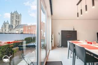 In de Mageleinstraat vinden we dit high-end afgewerkt appartement met uitzicht op de iconische torens van Gent. Het is gelegen in een kleinschalige residentie op een uitzonderlijke locatie. Het onderging een kwalitatieve totaalrenovatie in 2019. Er werd veel aandacht besteed aan duurzaamheid, onderhoudsvriendelijkheid en wooncomfort. Het appartement is een uniek vastgoed, ideaal voor mensen die houden van een bruisend stadsleven in Gent. <br /><br />We wandelen binnen in een aangename inkomruimte. Aan de linkerkant bevindt zich de open en zeer lichtrijke leefruimte. Deze omvat een open en hyper-uitgeruste keuken, uitgerust met een ingebouwde oven, microgolf, vaatwasser, spoelbak, inductiekookplaat, koelkast en diepvriezer. Koken met uitzicht op de Sint-Niklaaskerk, een uniek gegeven. Verder vinden we hier nog een ruime zithoek en eetplaats. Aan de andere kant van het appartement bevindt zich de comfortabele slaapkamer, de badkamer met inloopdouche en wastafel en een apart toilet. Het appartement heeft ook een zonnig terras. <br /><br />Extra troeven: de meubels die op de foto’s staan kunnen ook overgenomen worden en er is een kelderberging in de prijs inbegrepen. Er is een lift in het gebouw.<br /><br />Wenst u graag meer info en/of een bezoek? Contacteer dan Benjamin De Wit (benjamin@rosseel.be of 0473 97 08 80).