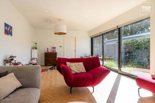 Deze gerenoveerde halfopen bebouwing is gelegen in een rustige, autoluwe en kindvriendelijke straat, op korte afstand van scholen, winkels en de R4.<br /><br />De woning werd mooi gerenoveerd en geniet dankzij de vele raampartijen van bijzonder veel natuurlijk licht. <br /><br />De ruime living en keuken zijn beide zeer lichtrijk en dienen als aangename en open leefruimtes.<br /><br />Verder beschikt de woning over drie slaapkamers, twee toiletten en een praktische indeling. <br /><br />Vooraan is er een eigen oprit met toegang tot de zeer ruime garage, die naast plaats voor de wagen ook als wasplaats dient en heel wat extra berg- en opbergruimte biedt.<br /><br />Achteraan bevindt zich de aangename tuin, die rechtstreeks grenst aan een rustige speeltuin. Een mooie extra troef die de woning bijzonder geschikt maakt voor gezinnen met kinderen.<br /><br />Een instapklare gezinswoning die een rustige ligging combineert met veel licht, ruimte en praktisch comfort, met scholen, winkels en de R4 vlot bereikbaar.<br /><br />Bel Top Vastgoed voor een bezoek op 0475 700 700