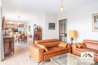 Dit moderne appartement is gelegen op de tweede verdieping van het complex, en is te bereiken via zowel lift als trap. Je wordt verwelkomd in een lange centrale gang, die alle ruimtes van het pand met elkaar in verbinding stelt. Een stijlvolle zwartmetalen glasdeur brengt je tot in een heel erg lichtrijke leefruimte met open keuken. De grote raampartijen vormen een venster op de heel leuke en rustige omgeving, en het ruime terras voelt als een natuurlijk verlengstuk van de woonruimte. De keuken is voorzien van hoogwaardig kookcomfort, en voorzien van alle gemak. De ruime aanpalende berging/wasplaats is handig meegenomen. Aan de achterzijde van het pand bevinden zich de drie slaapkamers (waarvan de master bedroom beschikt over wandhoge ingemaakte kasten) en een luxueuze badkamer met een riante inloopdouche. Bij het appartement horen twee opbergruimtes in de kelder en een garagebox met sectionaalpoort verplicht aan te kopen voor €30 000. De omgeving is zeer rustig, maar alle mogelijkheden tot ontspanning zijn vlakbij. De ondergrondse parkeergarage is bereikbaar via een inrit aan de achterzijde van het complex. Bezoekdag 30/05. Inschrijven via mail naar tommy@immo-home.be, geen telefonische inschrijvingen! Volg ons op Fb en Insta. Voor meer info: www.immo-home.be. GRATIS SCHATTING & GRATIS FINANCIEEL ADVIES