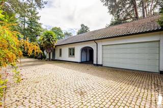 <strong>Renovatieproject op een prachtig perceel van ca. 8.300 m²</strong><br /><br /><strong>Op een uitzonderlijk groen perceel van ca. 8.300 m², met een indrukwekkende straatbreedte van ca. 83 meter, bevindt zich deze karaktervolle woning met bijzonder veel potentieel. De toplocatie in Hof ter Linden, de lange oprijlaan en de groene omkadering zorgen voor een unieke combinatie van ruimte, rust en absolute privacy.</strong><br /><br /><strong>De bestaande woning is volledig gelijkvloers opgevat in een U-vorm en biedt tal van mogelijkheden voor een grondige renovatie en herinrichting, rekening houdend met de huidge bouwvoorschriften. </strong><br /><br /><strong>Gelijkvloerse verdieping</strong><br />
<ul>
<li>een ruime <strong>inkomhal</strong></li>
<li>een <strong>woonkeuken </strong>met spoelbak en diverse inbouwtoestellen</li>
<li>een <strong>eetkamer</strong> op parket</li>
<li>een sfeervolle <strong>bibliotheek</strong> op parket met ingemaakte kasten</li>
<li>een ruime <strong>woonkamer </strong>op parket met open haard en doorgang naar buiten</li>
<li>een eerste <strong>slaapkamer</strong> op parket</li>
<li>een royale <strong>hoofdslaapkamer</strong> met <strong>dressing</strong> en ensuite <strong>badkamer</strong>, volledig uitgevoerd in marmer en voorzien van ligbad, douche, dubbele lavabo en toilet</li>
<li>een <strong>derde slaapkamer </strong>op parket met ingemaakte kasten</li>
<li>een <strong>tweede</strong> <strong>badkamer </strong>met ligbad en twee lavabo's</li>
<li>een apart <strong>toilet</strong></li>
<li>een ruim <strong>bureel </strong>met vestiaire, gastentoilet, ingemaakte kasten en technische kast, en<strong> aparte ingang</strong>, ideaal als kantoor aan huis, praktijk- of ontvangstruimte</li>
<li>een <strong>vierde slaapkamer</strong> op parket met toegang tot de badkamer</li>
<li>een volledig ingerichte <strong>bijkeuken</strong> met inbouwtoestellen en dubbele spoelbak</li>
<li>een ruime <strong>hobbykamer/polyvalente ruimte/tuinkamer</strong></li>
<li>een dubbele inpandige <strong>garage </strong>met zolderruimte</li>
</ul>
<strong>Kelder</strong><br />
<ul>
<li>een praktische <strong>kelder</strong></li>
<li>een afzonderlijke <strong>wijnkelder</strong></li>
<li>extra <strong>bergruimte</strong></li>
</ul>
<strong>Algemeen:</strong><br />
<ul>
<li><strong>Toplocatie in Hof ter Linden</strong></li>
<li><strong>Uitzonderlijk perceel </strong>met <strong>bijzonder veel potentieel</strong></li>
<li>Volledig <strong>gelijkvloerse </strong>woning in <strong>karaktervolle U-vorm</strong></li>
<li><strong>Interessante</strong> <strong>mogelijkheden </strong>voor een <strong>grondige renovatie </strong>en <strong>herinrichting</strong></li>
<li>Huidige constructie niet volledig vergund</li>
<li><strong>Renovatie mogelijk aan 6% btw (onder voorwaarden) </strong></li>
</ul>
<strong>Gelegen in de gegeerde omgeving van Hof ter Linden, waar de royale perceeloppervlakte, brede straatzijde, lange oprijlaan en groene omkadering een uitzonderlijk private woonomgeving creëren. Een unieke opportuniteit voor wie op zoek is naar een renovatieproject met ruimte, karakter en bijzonder veel mogelijkheden.</strong>