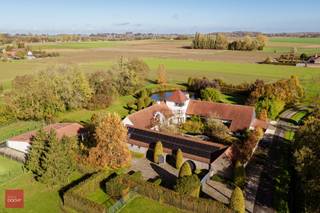 Gelegen op de grens met Wannegem-Lede, prachtig gerestaureerde vierkantshoeve op ca. 1,3ha bestaande uit inkomhal, living met open ingerichte...