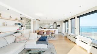 <span>Uitzonderlijke penthouse gelegen op de Zeedijk aan het Van Bunnenplein met panoramische zichten op land en zee en mooi zonneterras achteraan.</span><br /><br /><span>Indeling: inkom met videofoon, vestiaire, gastentoilet en berging.</span><br /><span>De ruime woonkamer met parketvloer biedt een adembenemend zicht op zee en over gans Knokke en leidt naar een royaal terras. De open keuken is voorzien van alle toestellen.</span><br /><span>Masterbedroom met ingemaakte kasten en ensuite badkamer uitgevend op het zuidgericht terras. Slaapkamer 2 met stapelbed, enkel bed en douchekamer, mogelijkheid om stapelbedden weg te doen en te vervangen door een dubbel bed.</span><br /><span>Kelder &amp; fietsenberging in de residentie.</span><br /><br /><span>Mogelijkheid tot aankoop van een dubbele gesloten garagebox in de residentie Grand Hotel.</span><br /><br /><span>Een bezoek is sterk aanbevolen om de volledige charme van dit appartement te ervaren!</span>